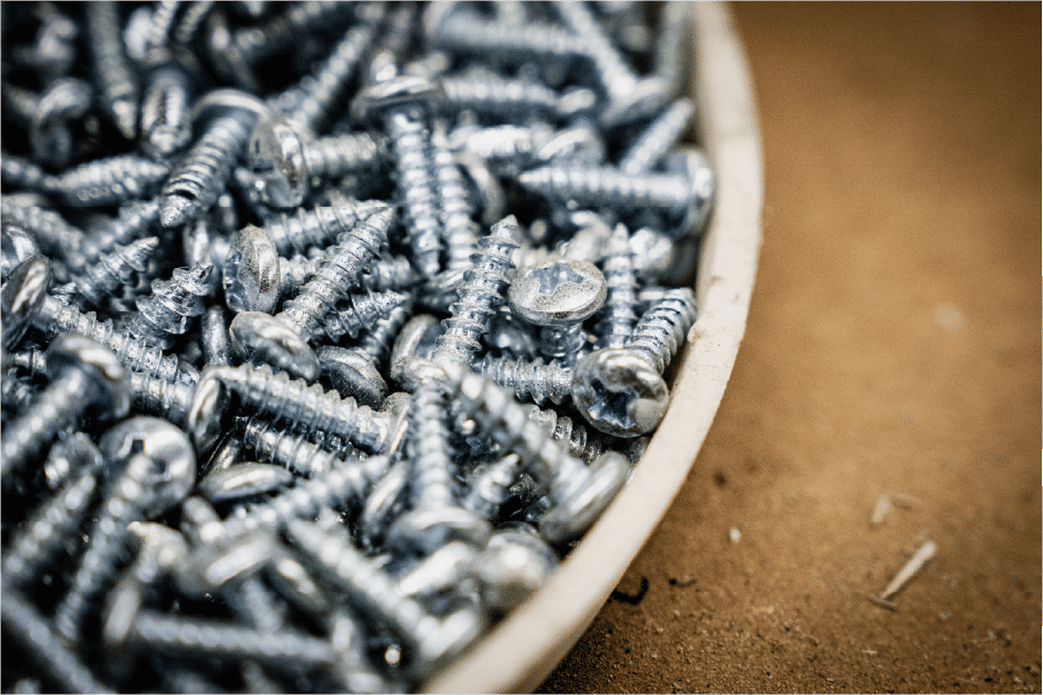 Metal screws piled inside small container