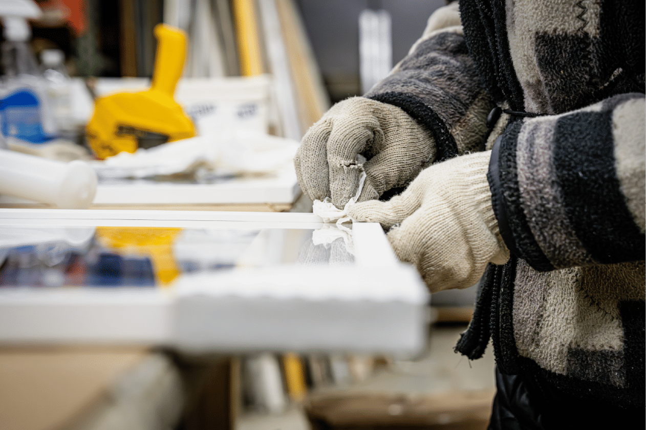 Worker cleaning frame edge removing excess adhesive