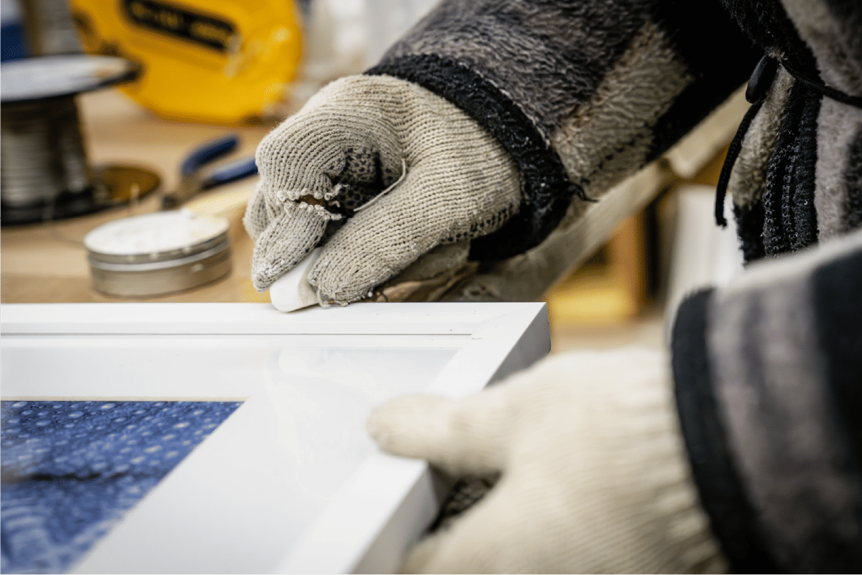 Applying adhesive along white frame edge carefully