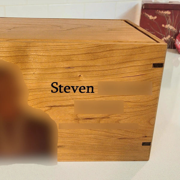 custom laser engraved wood urn for ashes - privacy blurred for client protection - showing sharp engraving detail on cherry wood