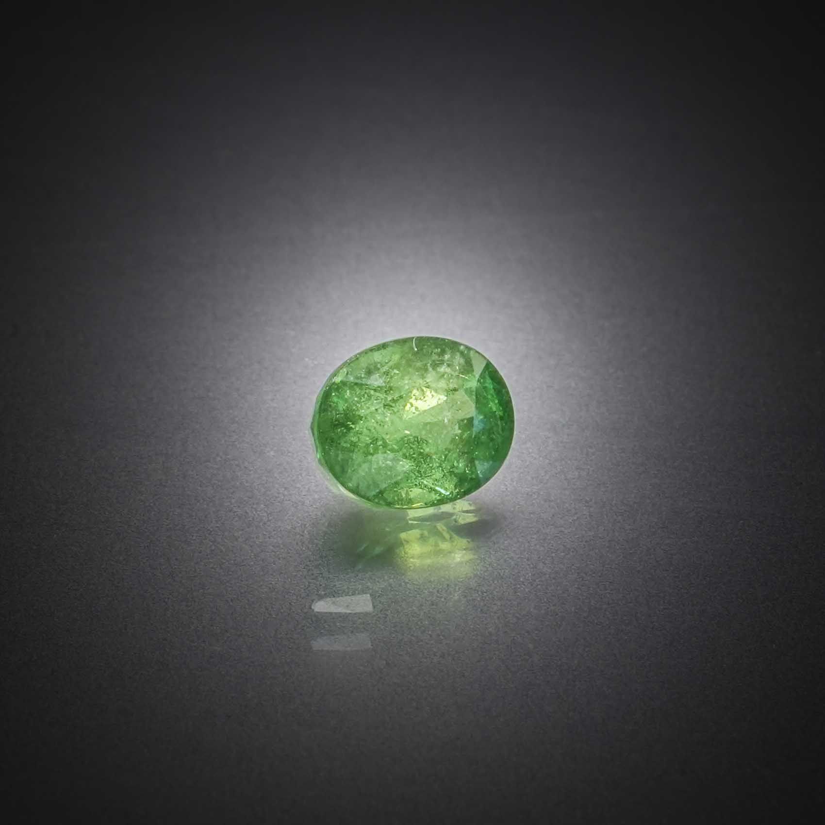 Grenat tsavorite ovale sur papier. - Lazuli