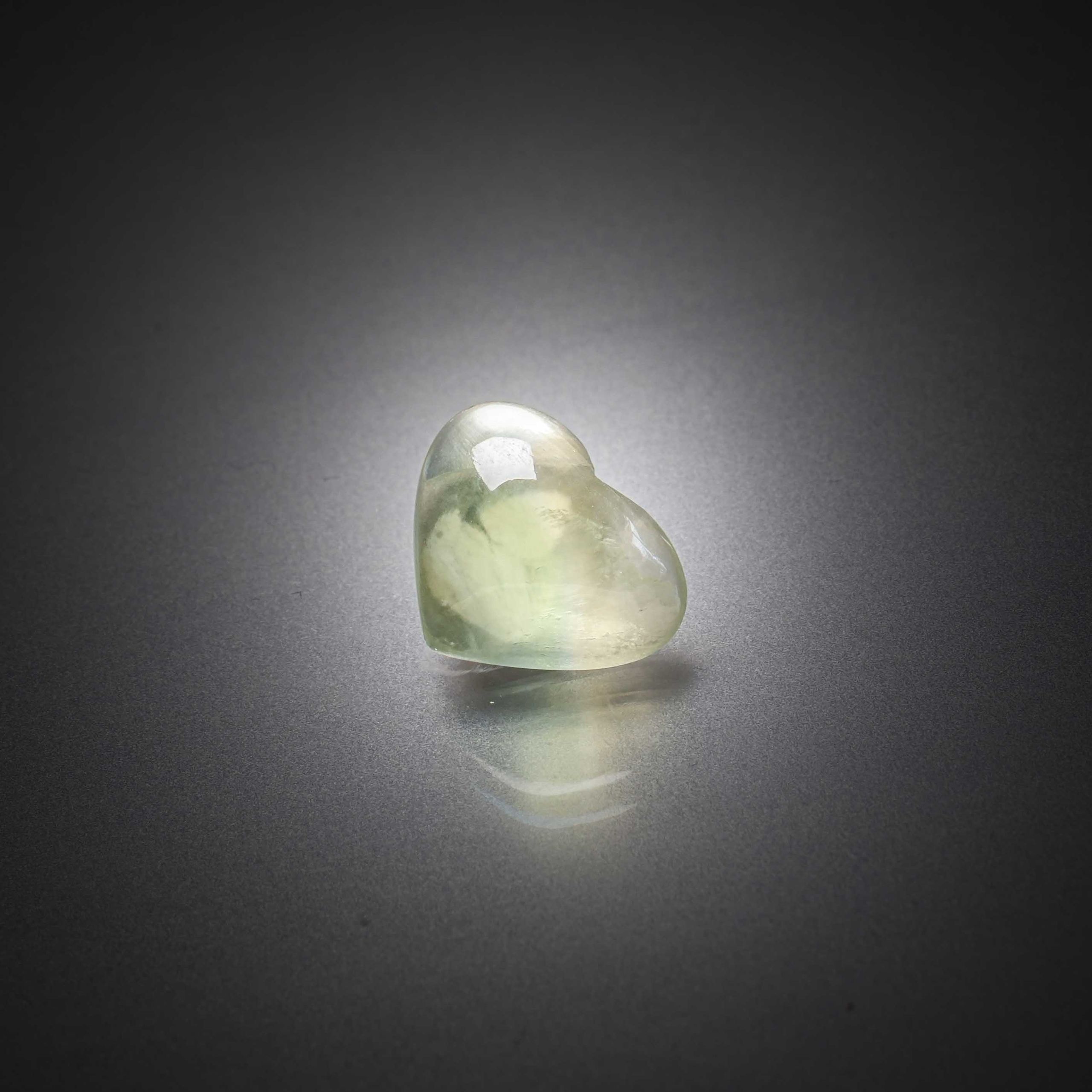 Sphène (titanite) vert ovale sur papier. - Lazuli