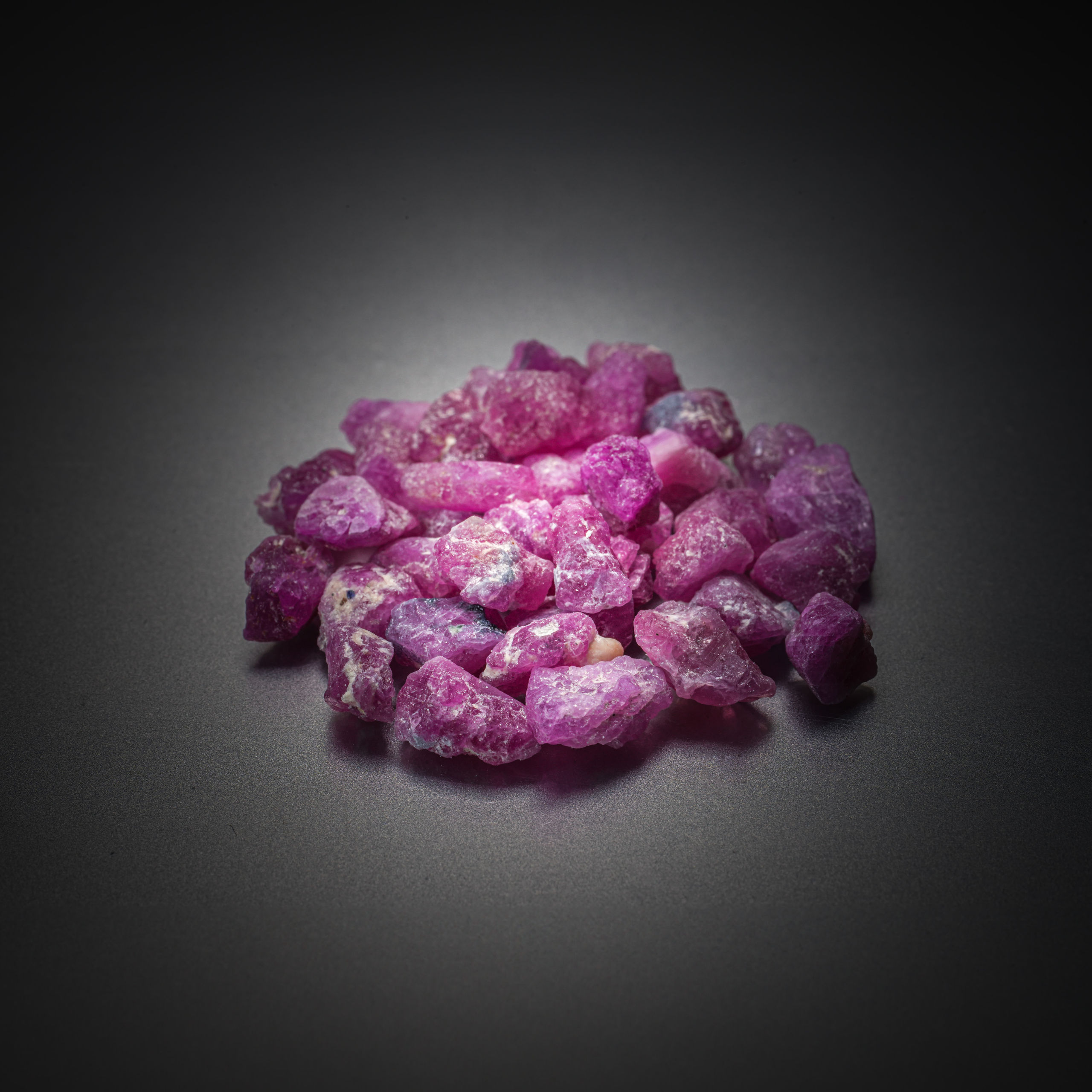 Lot de saphirs roses bruts sur papier. - Lazuli