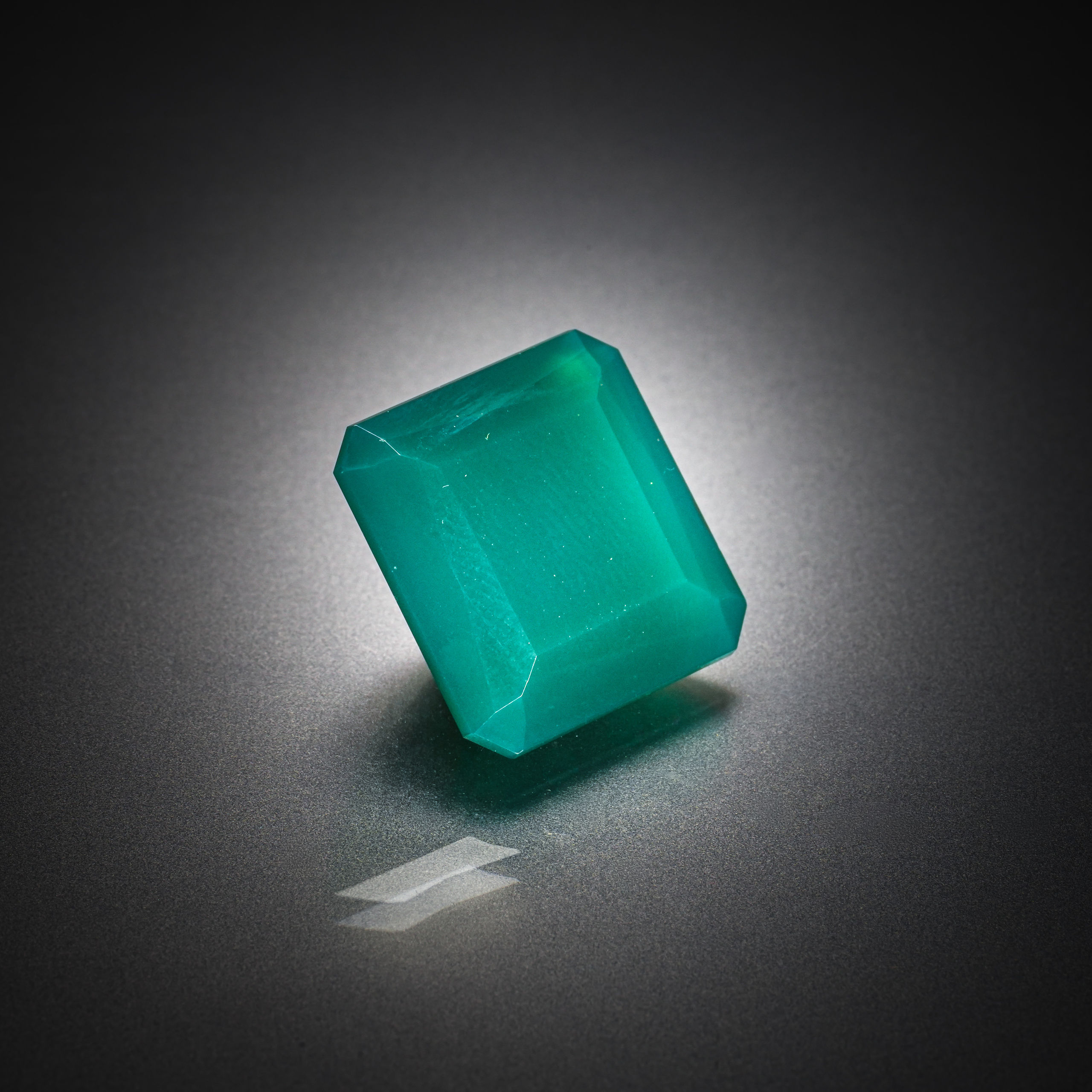 Calcédoine verte rectangulaire à pans coupés sur papier. - Lazuli