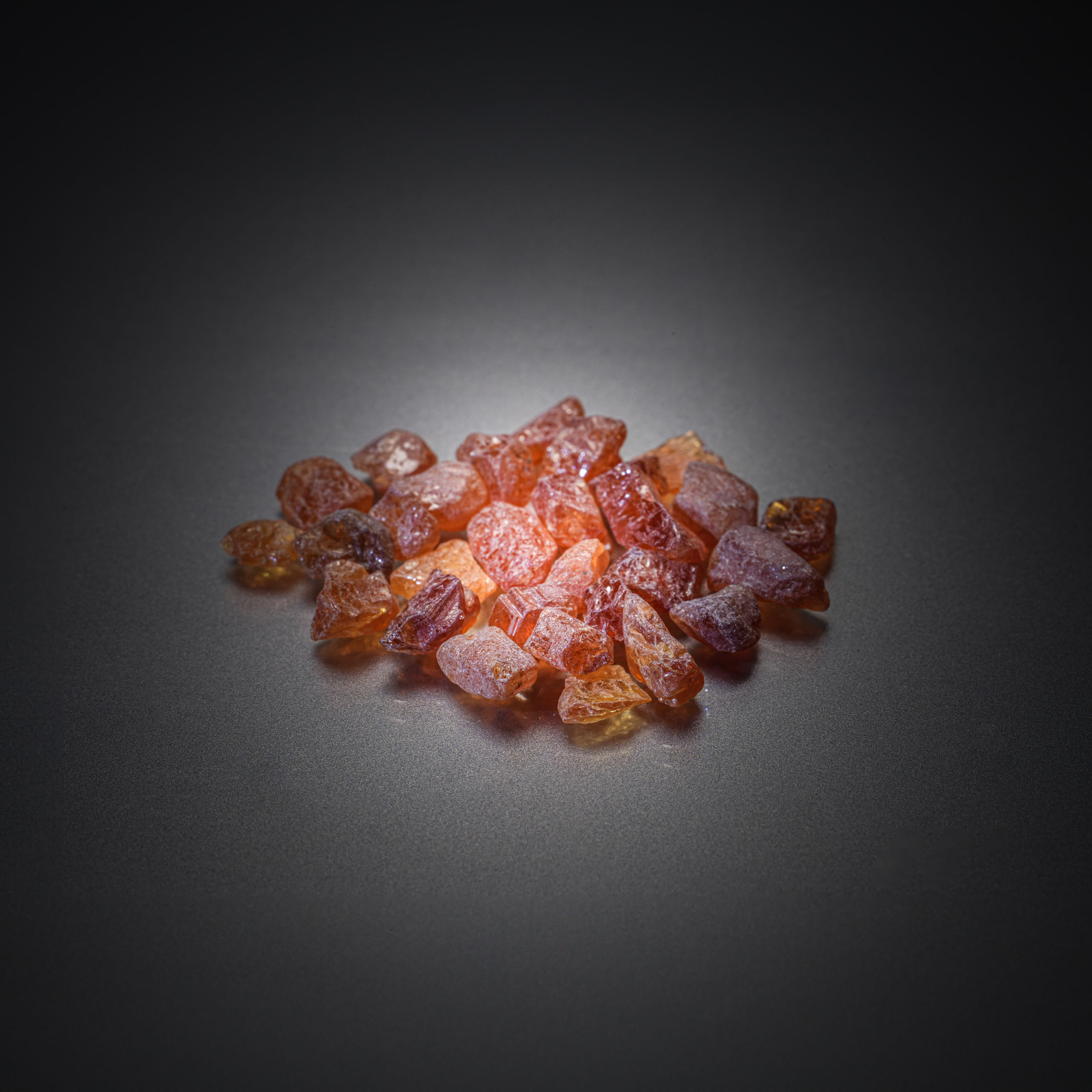 Lot de grenats spessartites oranges bruts sur papier. - Lazuli