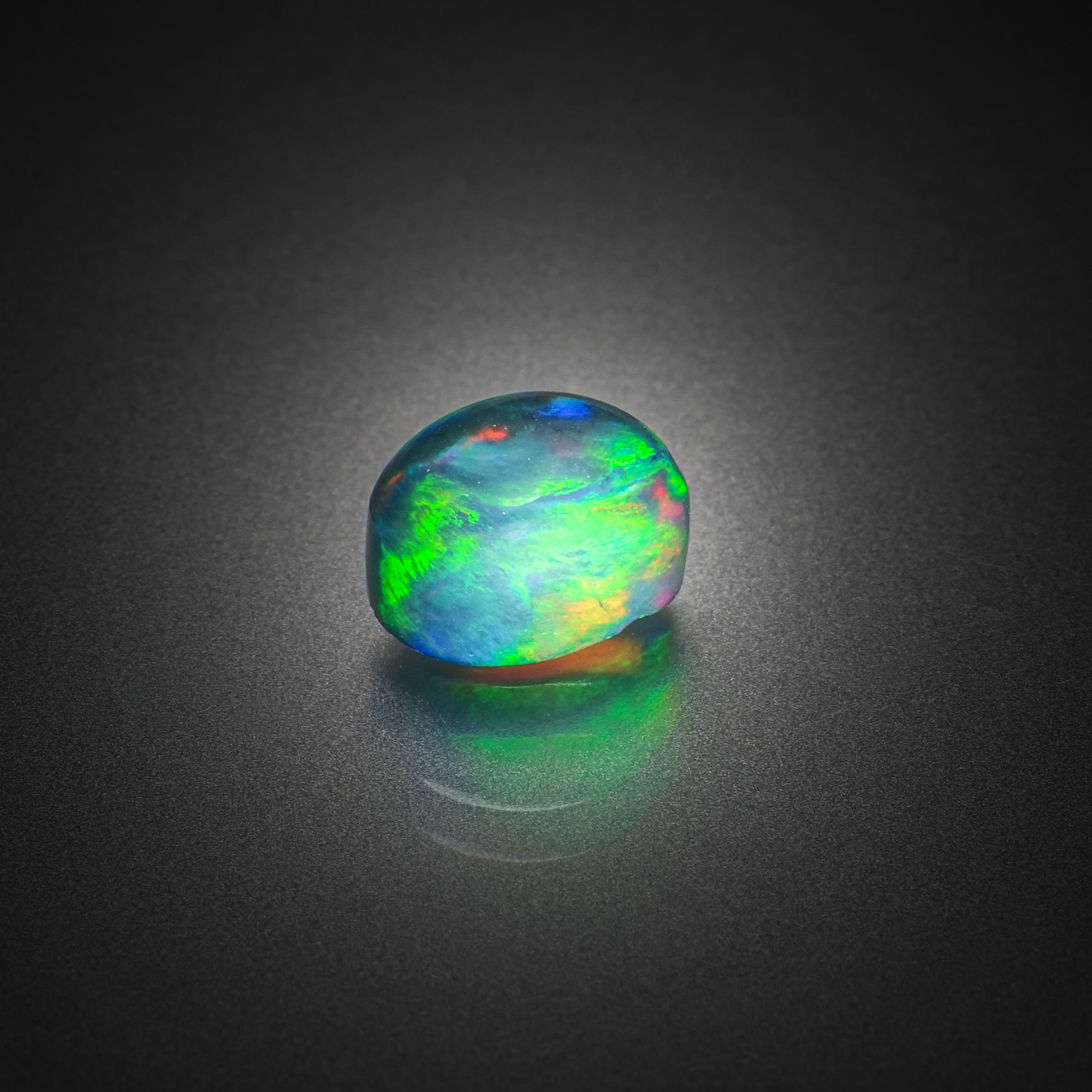 Opale noire ovale cabochon sur papier. - Lazuli
