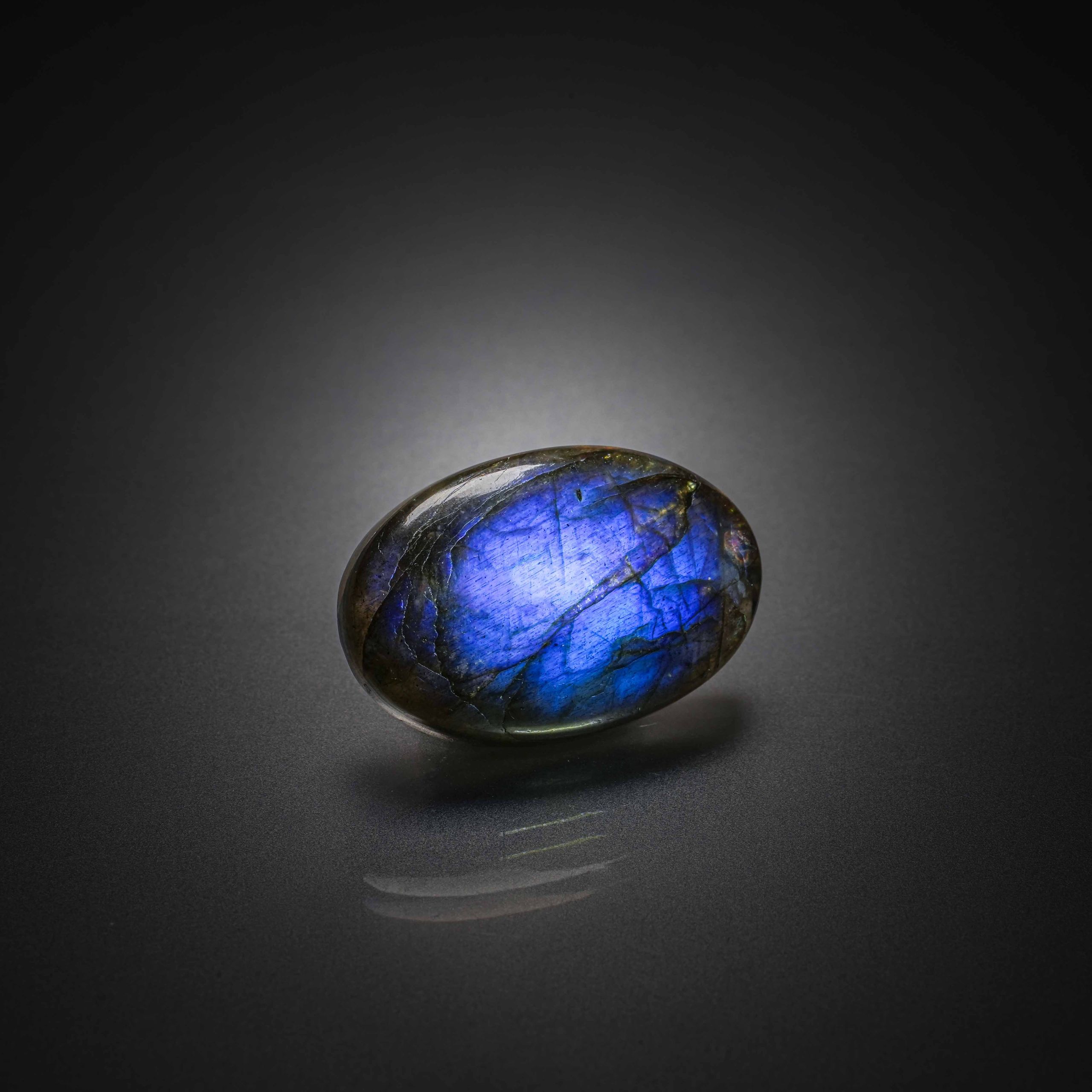 Opale noire ovale cabochon sur papier. - Lazuli