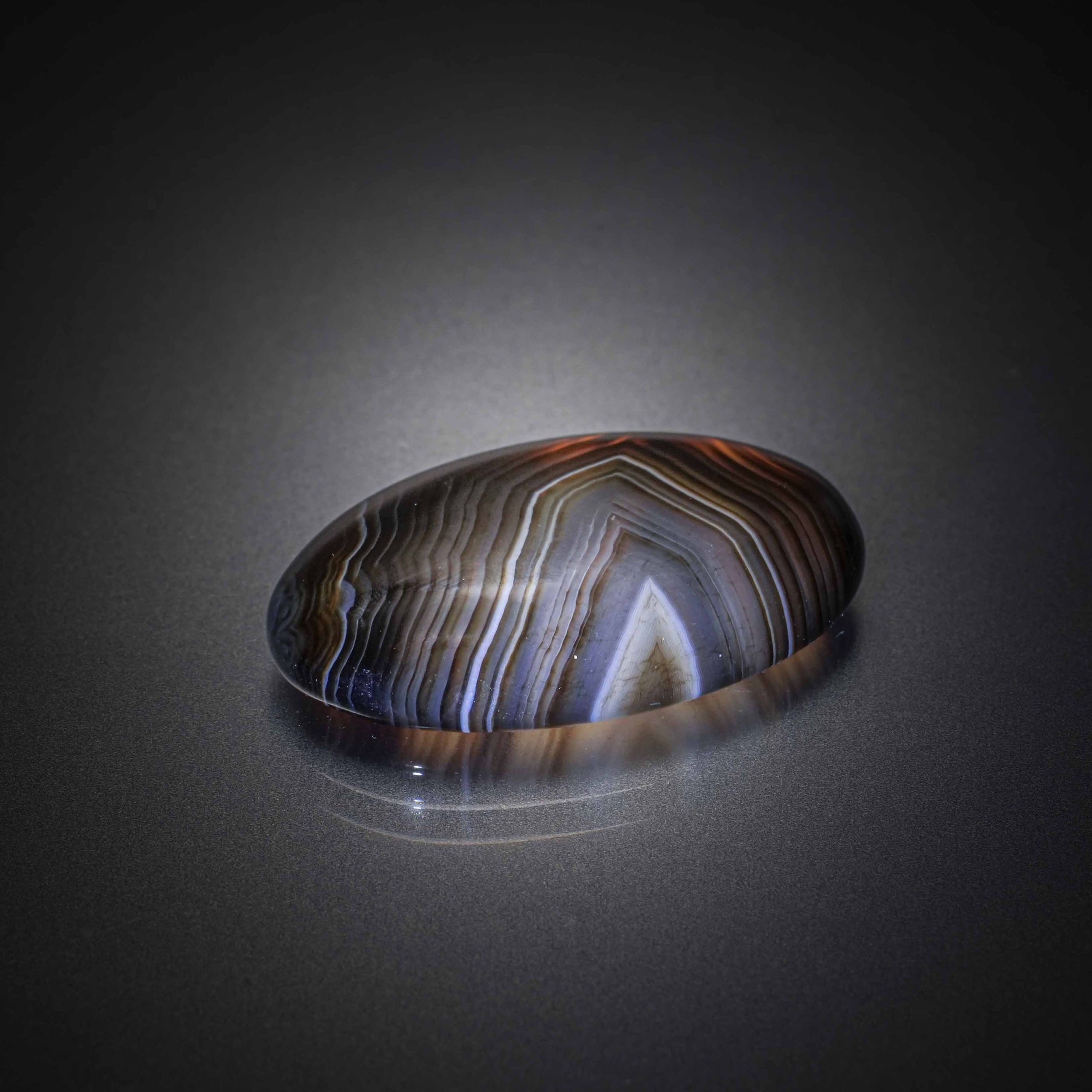 Agate multicolore ovale cabochon sur papier. - Lazuli