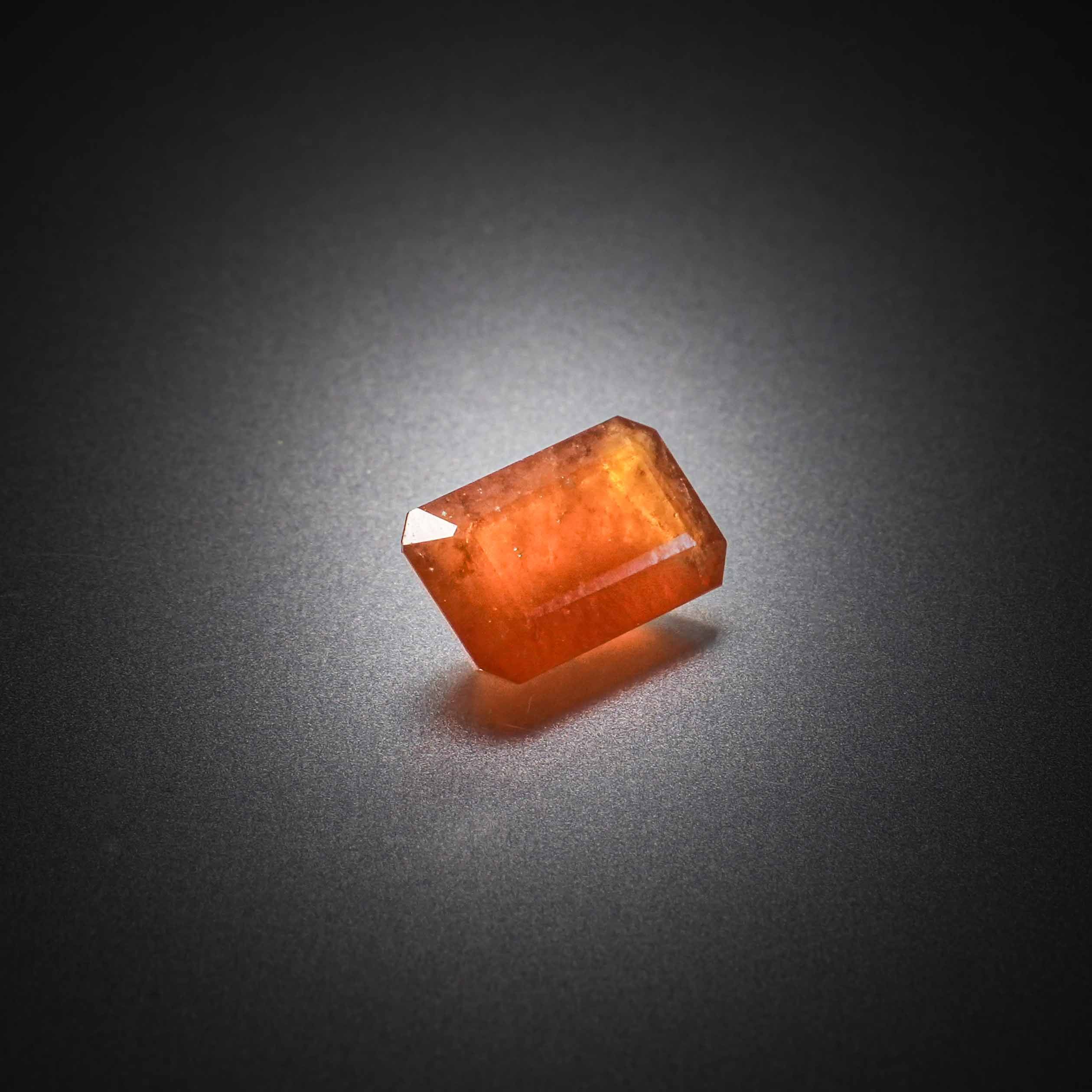 Grenat orange hessonite rectangulaire à pans coupés sur papier. - Lazuli
