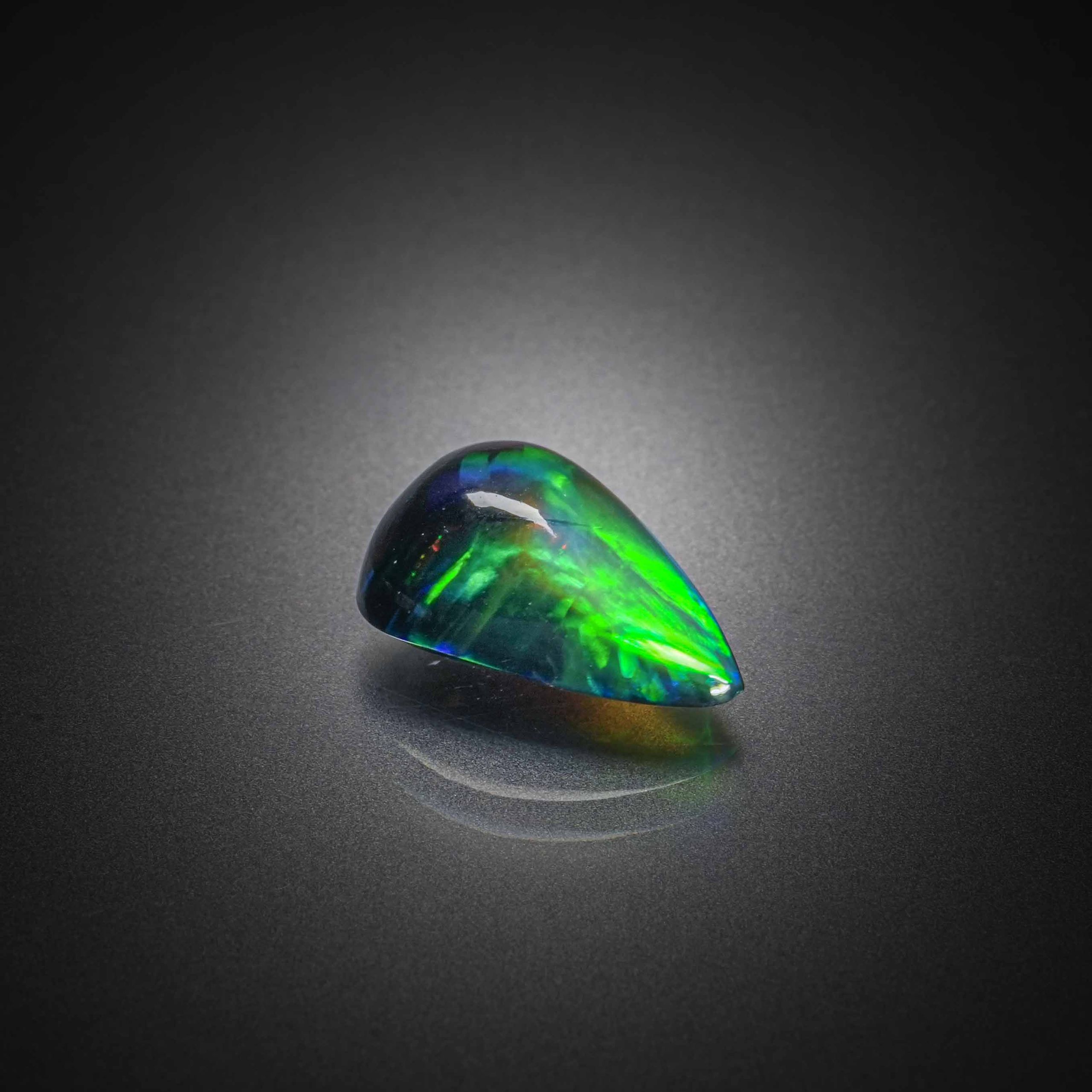 Opale noire poire cabochon sur papier. - Lazuli