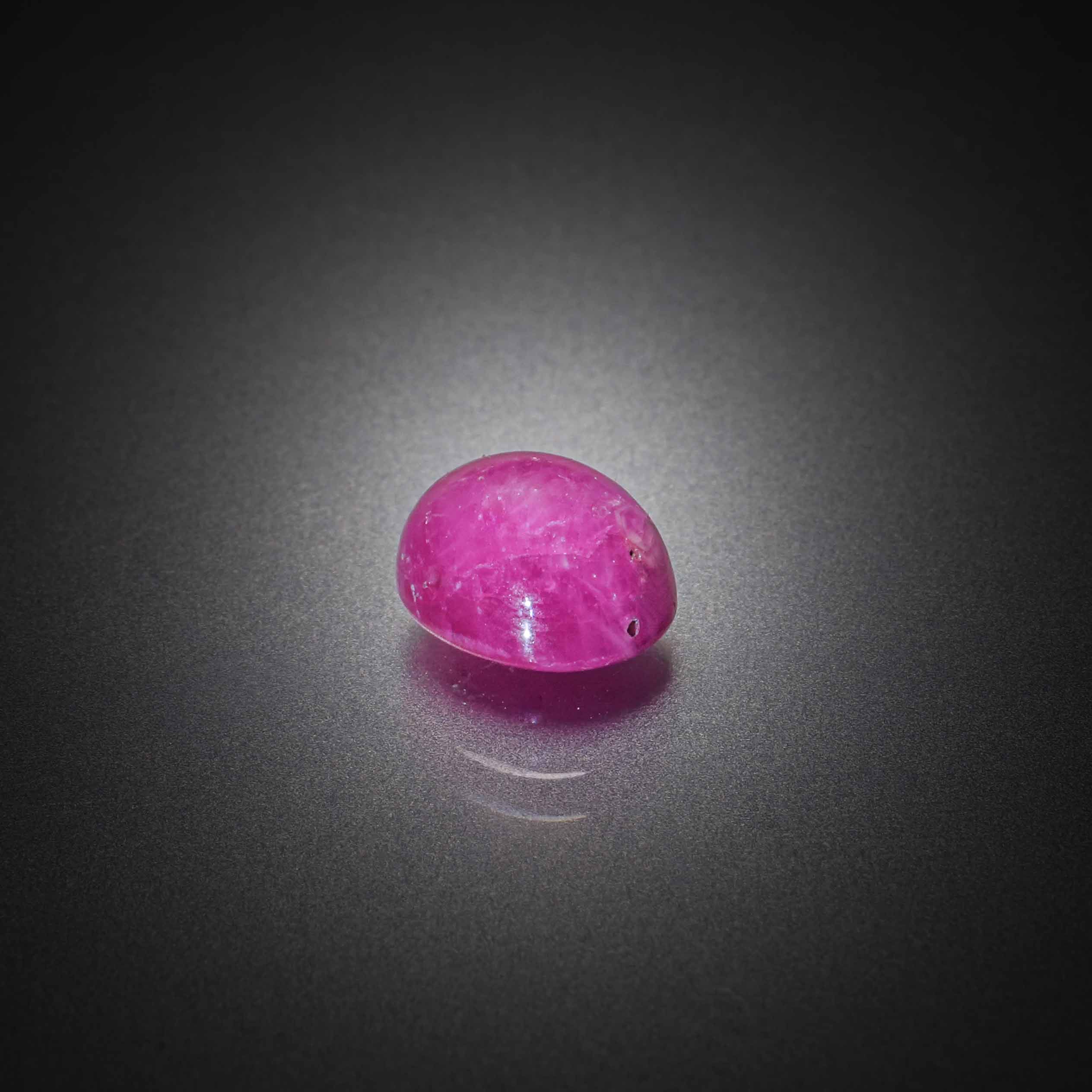 Rubis ovale cabochon sur papier. - Lazuli