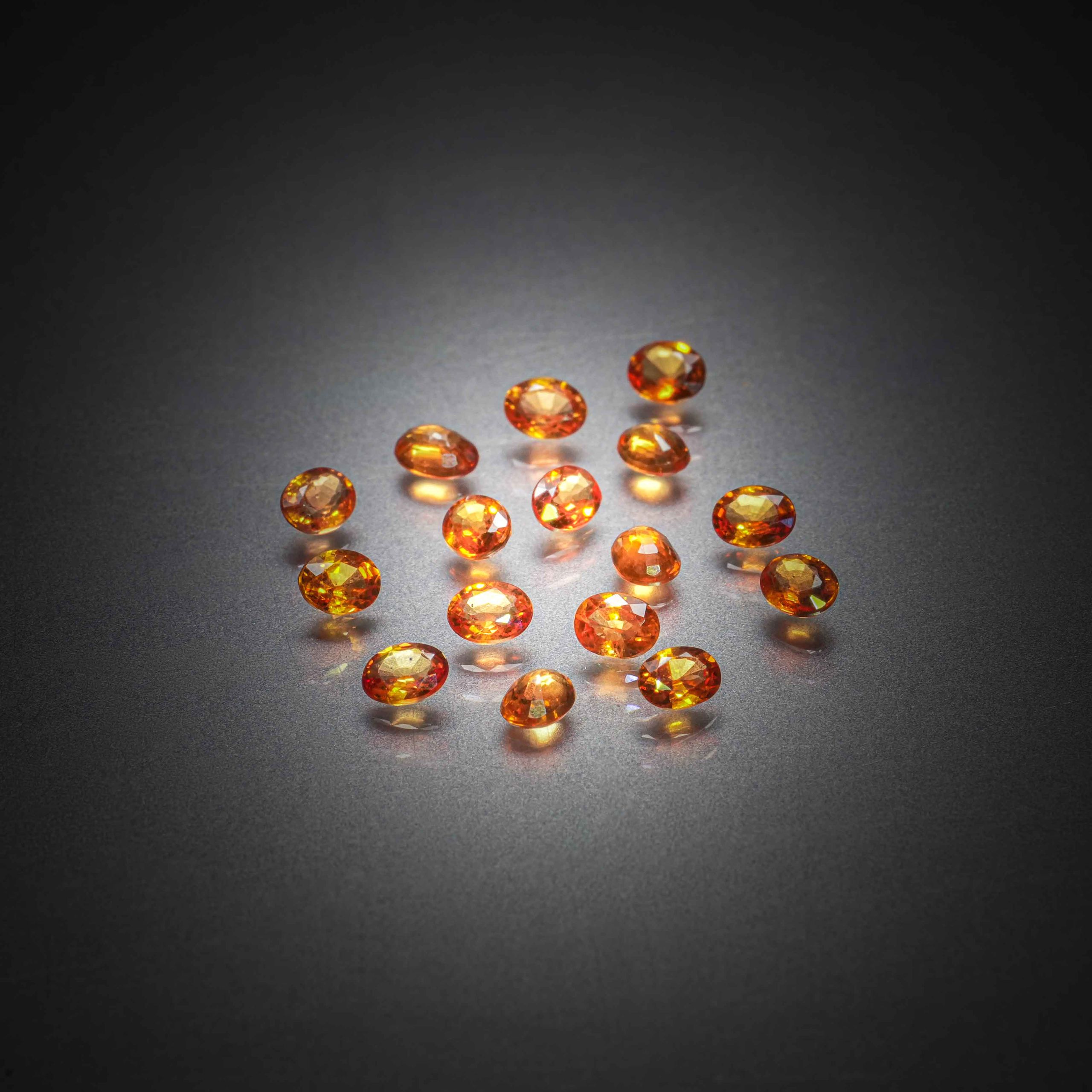 Lot de seize saphirs orange ovales sur papier. - Lazuli