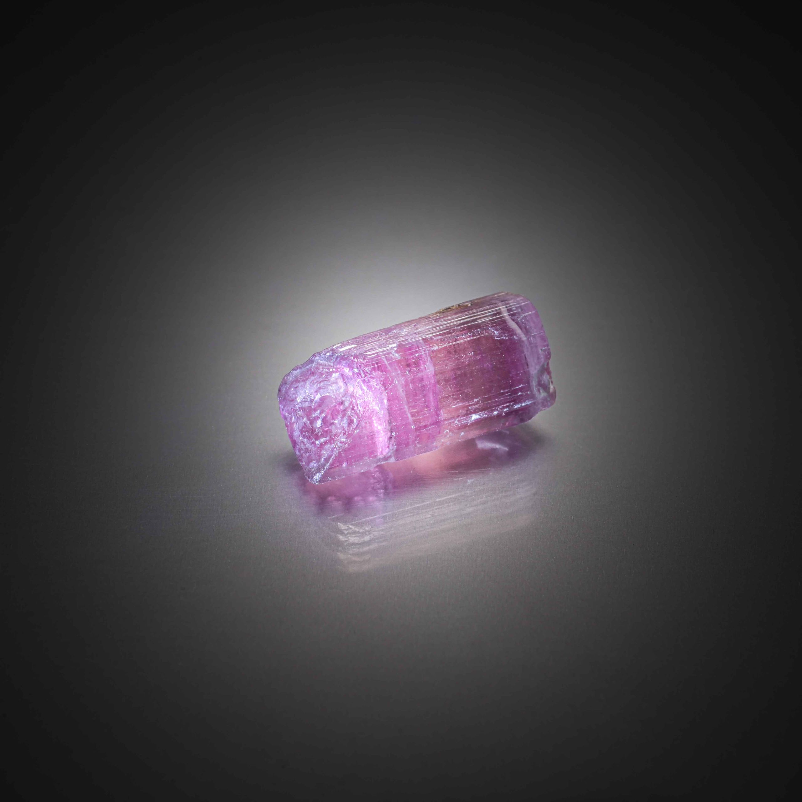 Grenat violet/rose rhodolite ovale sur papier. - Lazuli