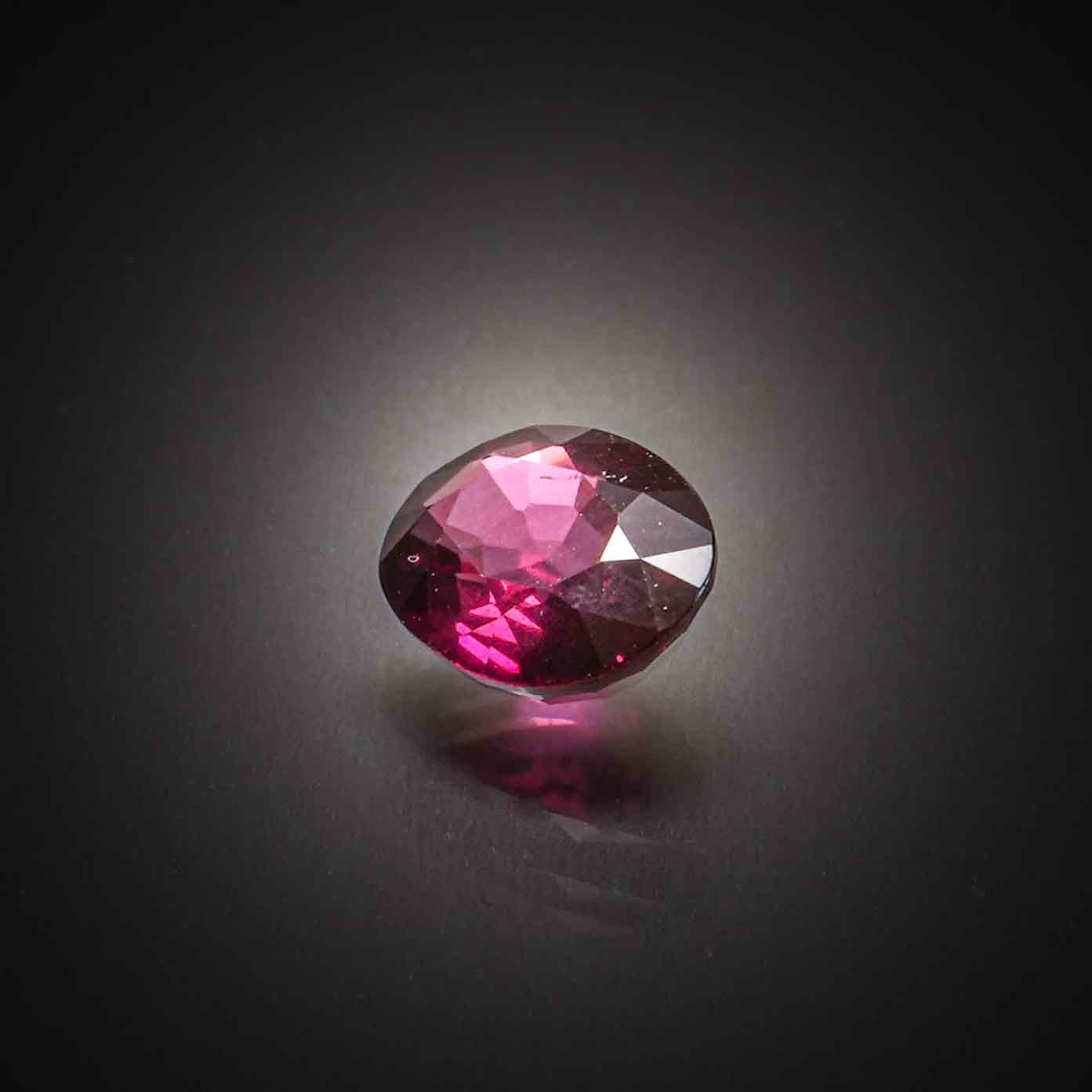 Grenat violet/rose rhodolite ovale sur papier. - Lazuli