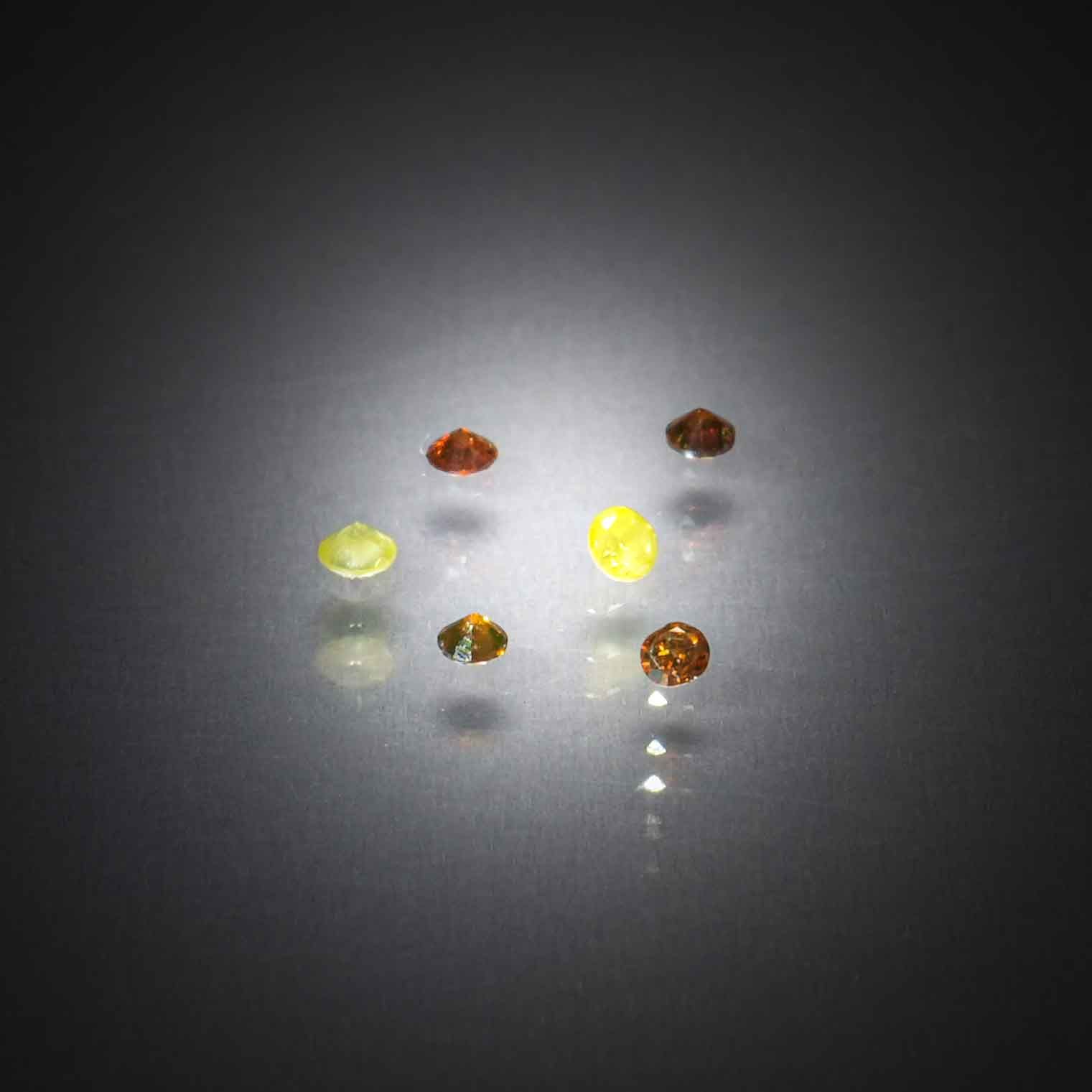 Lot de quatre diamants caramels et deux diamants jaunes ronds sur papier. - Lazuli