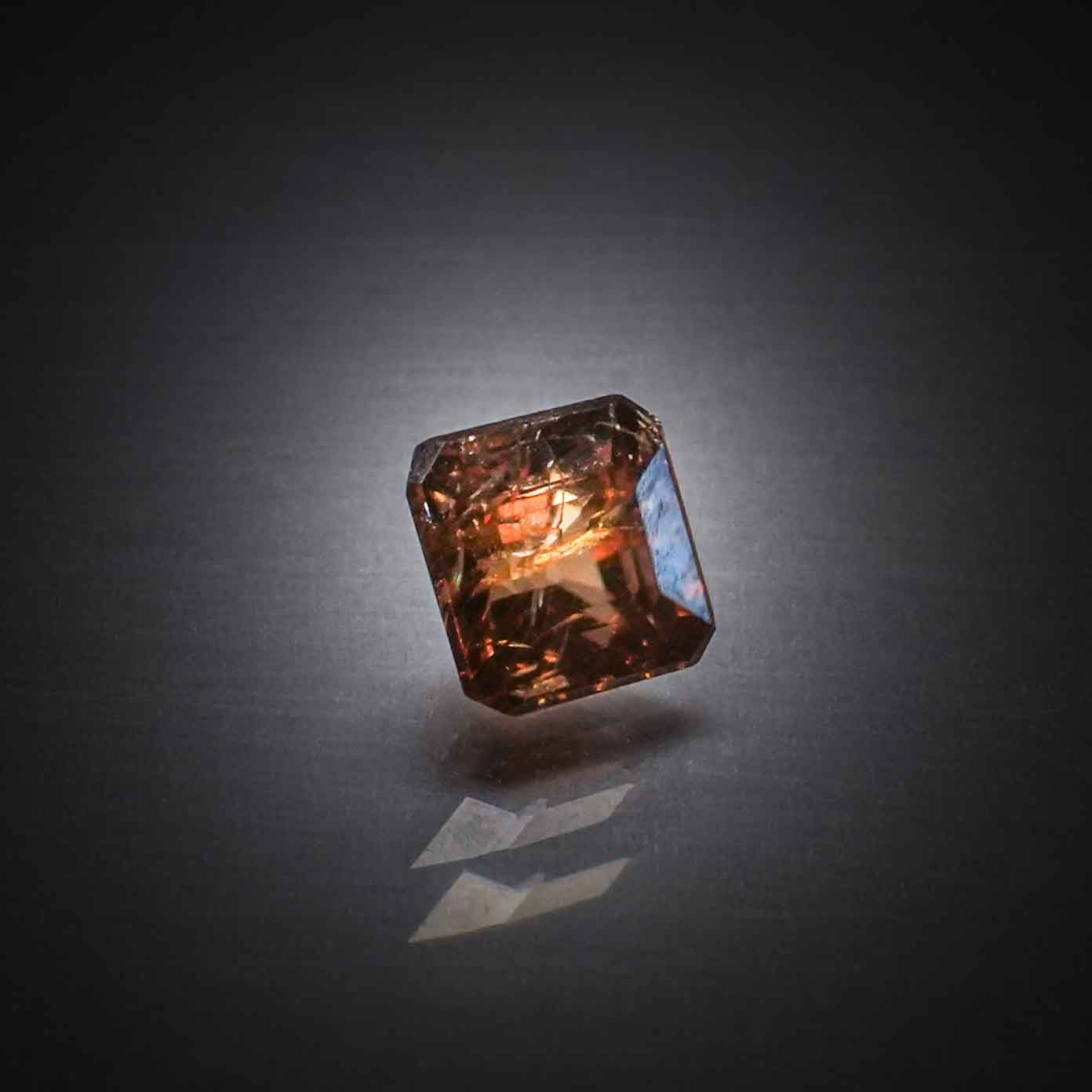 Zircon orange carré à pans coupés sur papier. - Lazuli