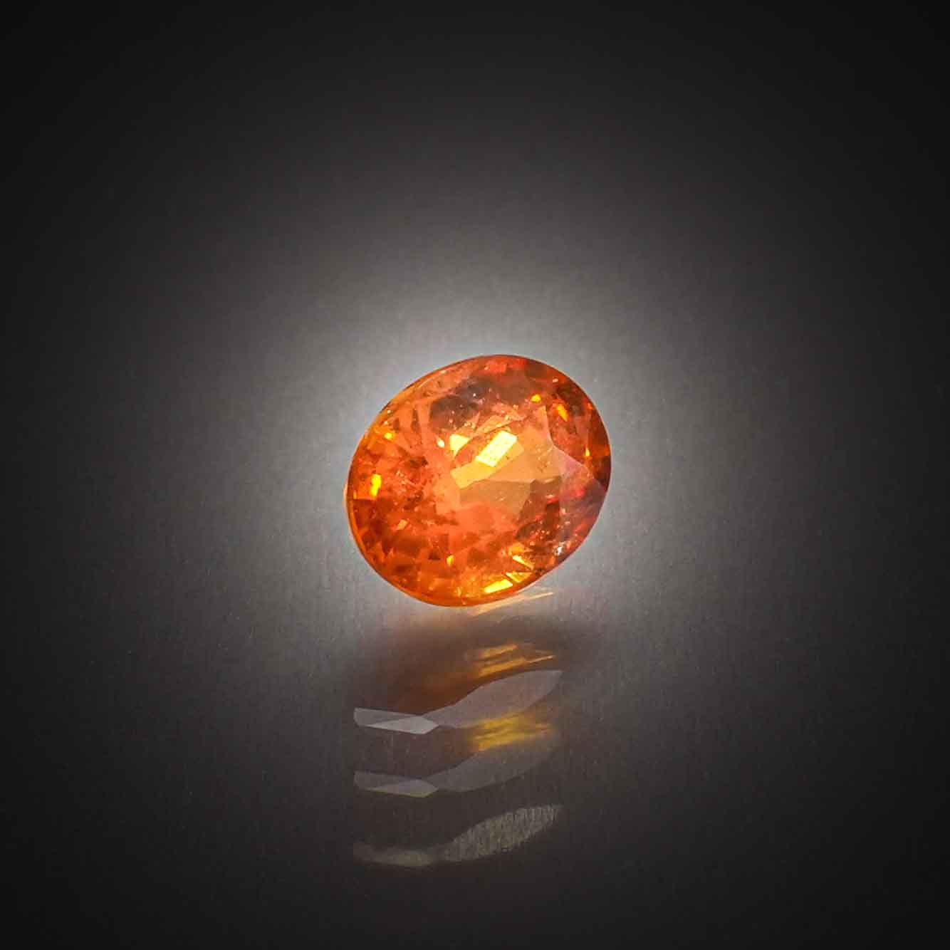 Grenat orange spessartite ovale sur papier. - Lazuli