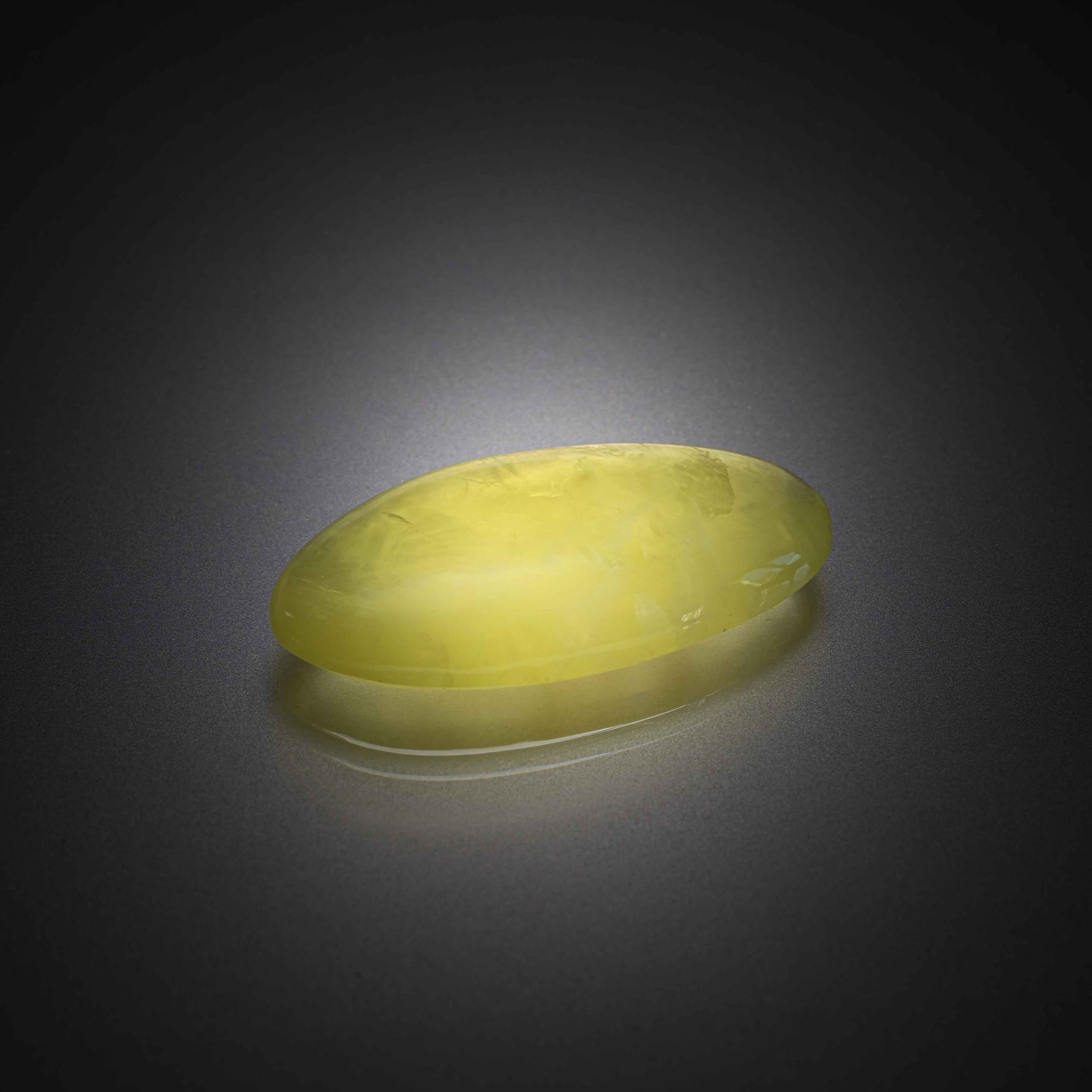 Prehnite jaune ovale cabochon sur papier. - Lazuli