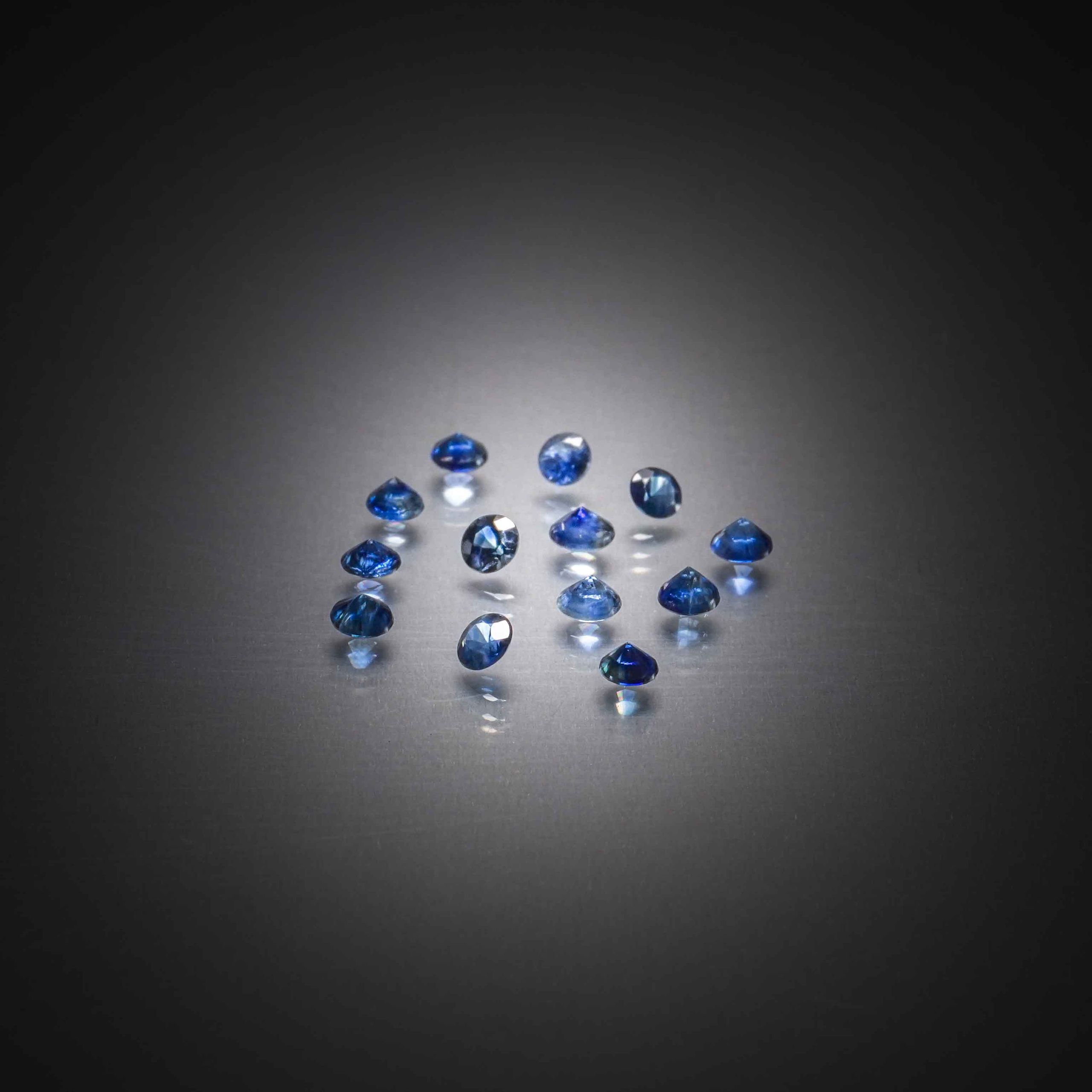 Lot de zircons bleus bruts sur papier. - Lazuli