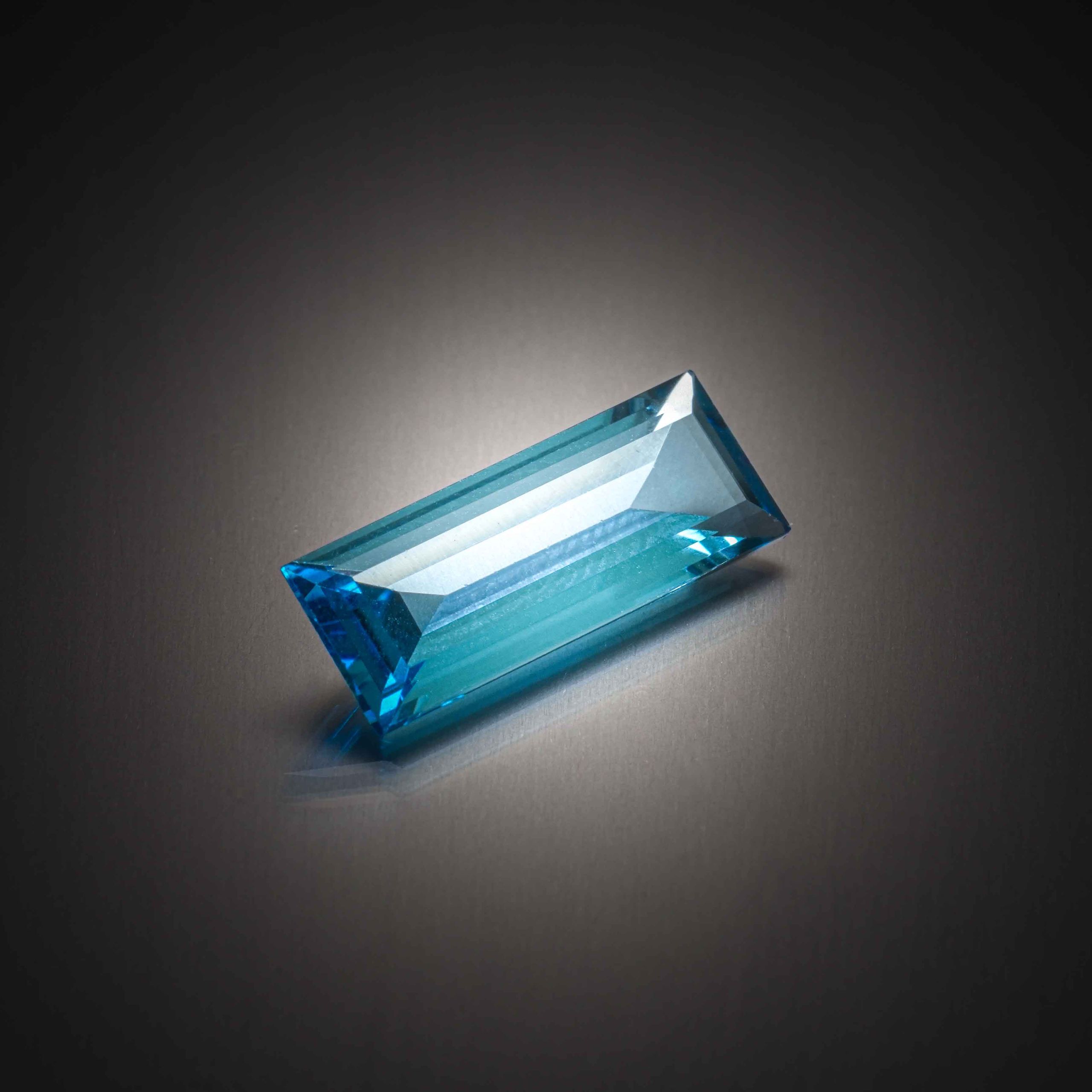 Topaze bleue (Swiss Blue) baguette sur papier. - Lazuli
