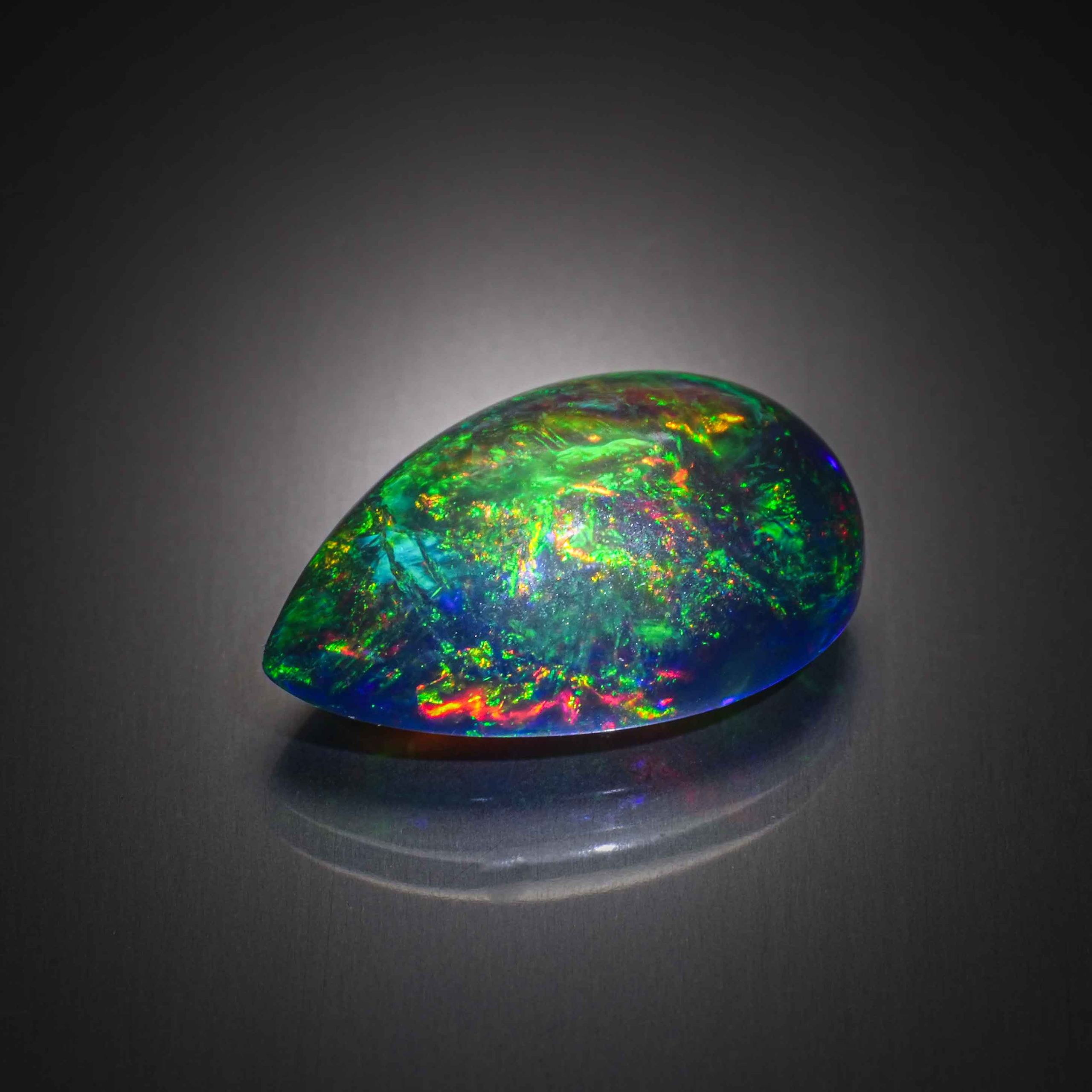 Opale noire poire cabochon sur papier. - Lazuli