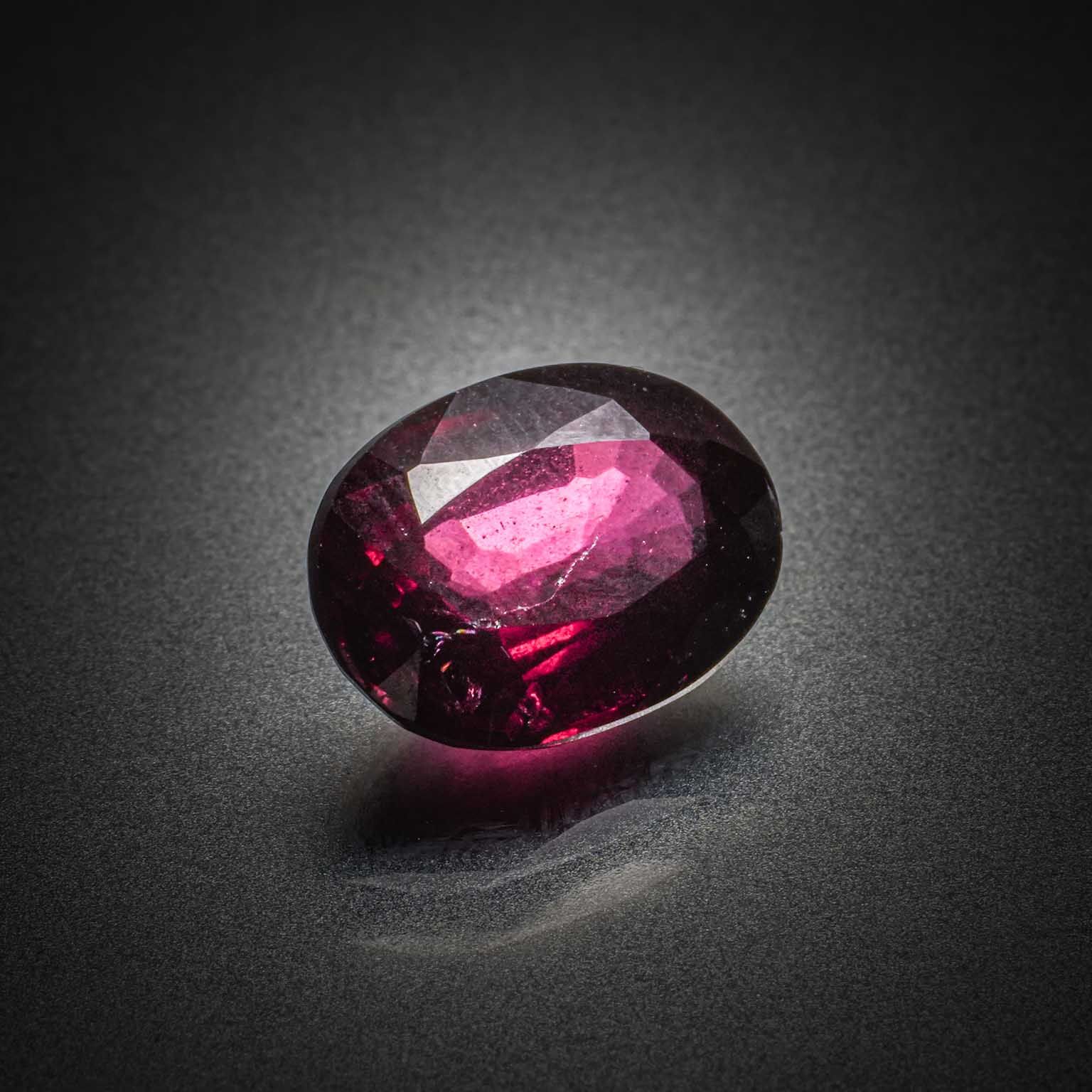 Grenat rose/violet rhodolite ovale sur papier. - Lazuli