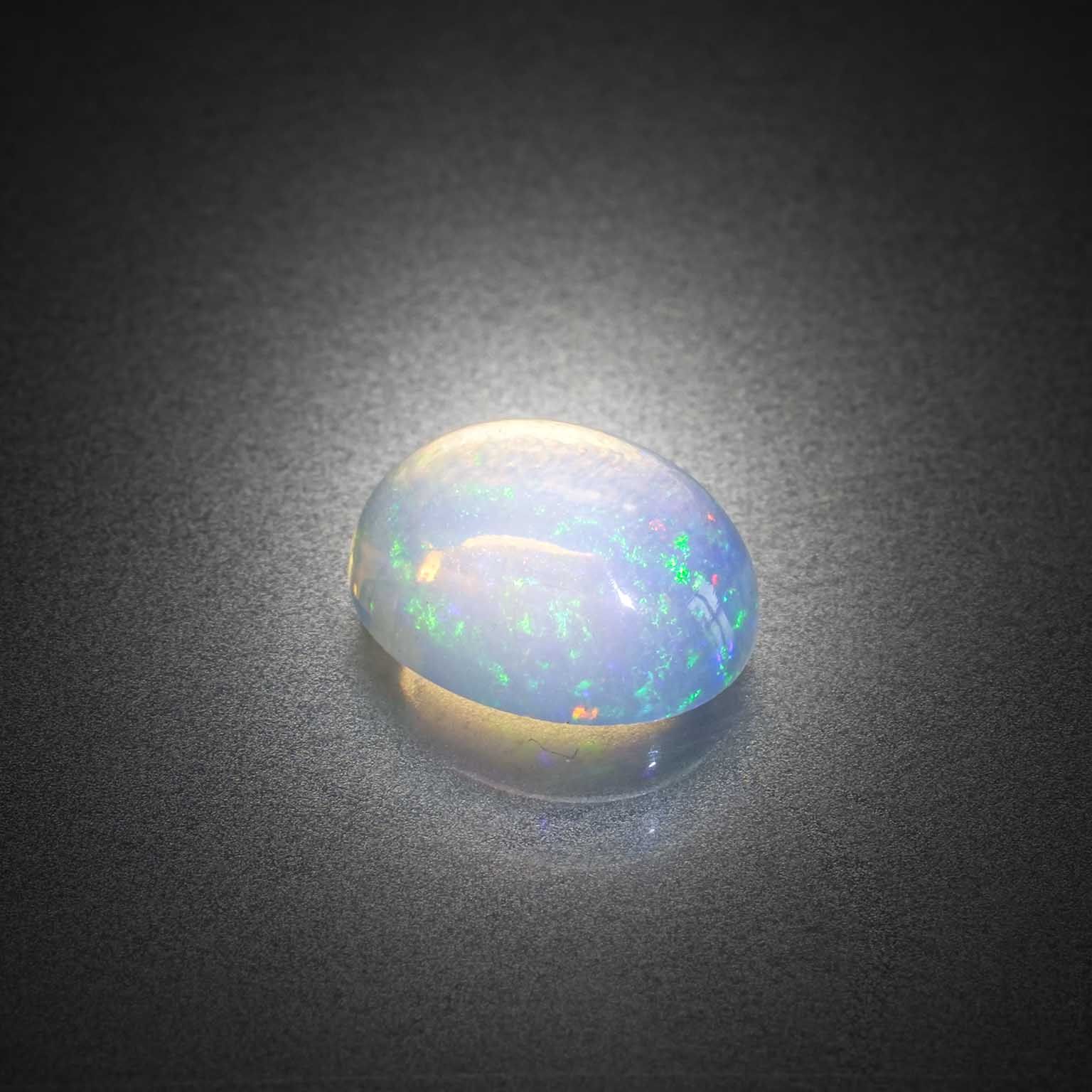 Opale ovale cabochon sur papier. - Lazuli