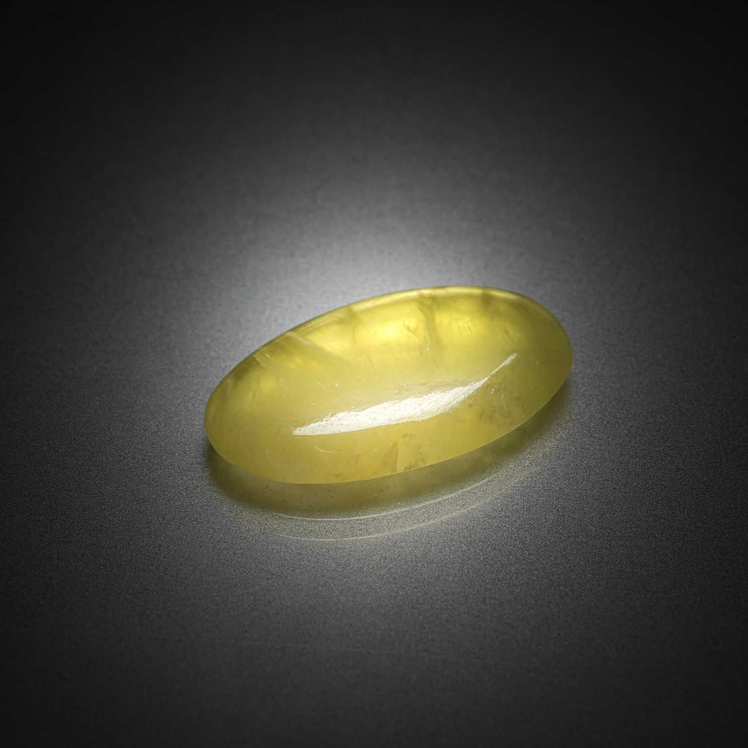 Prehnite jaune ovale cabochon sur papier. - Lazuli