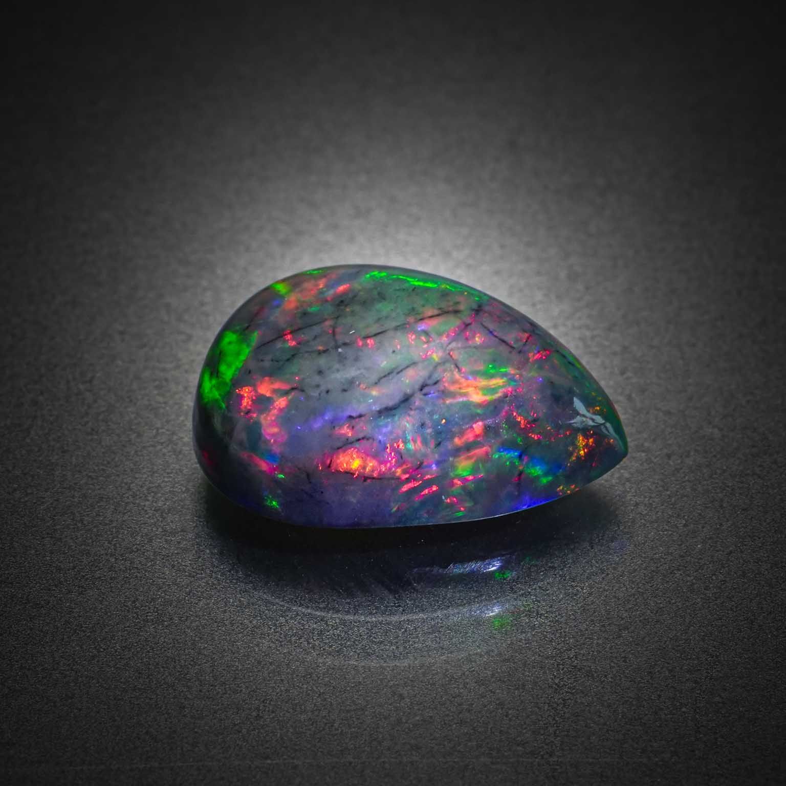 Opale noire poire cabochon sur papier. - Lazuli