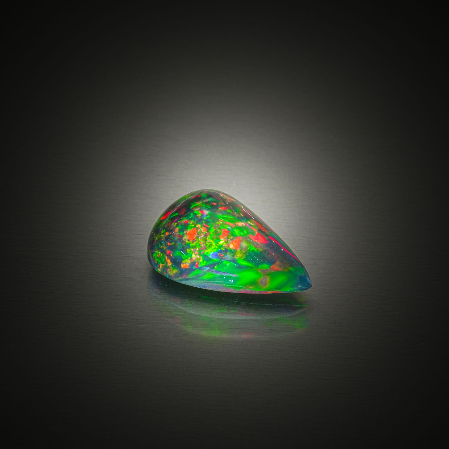 Opale noire poire cabochon sur papier. - Lazuli