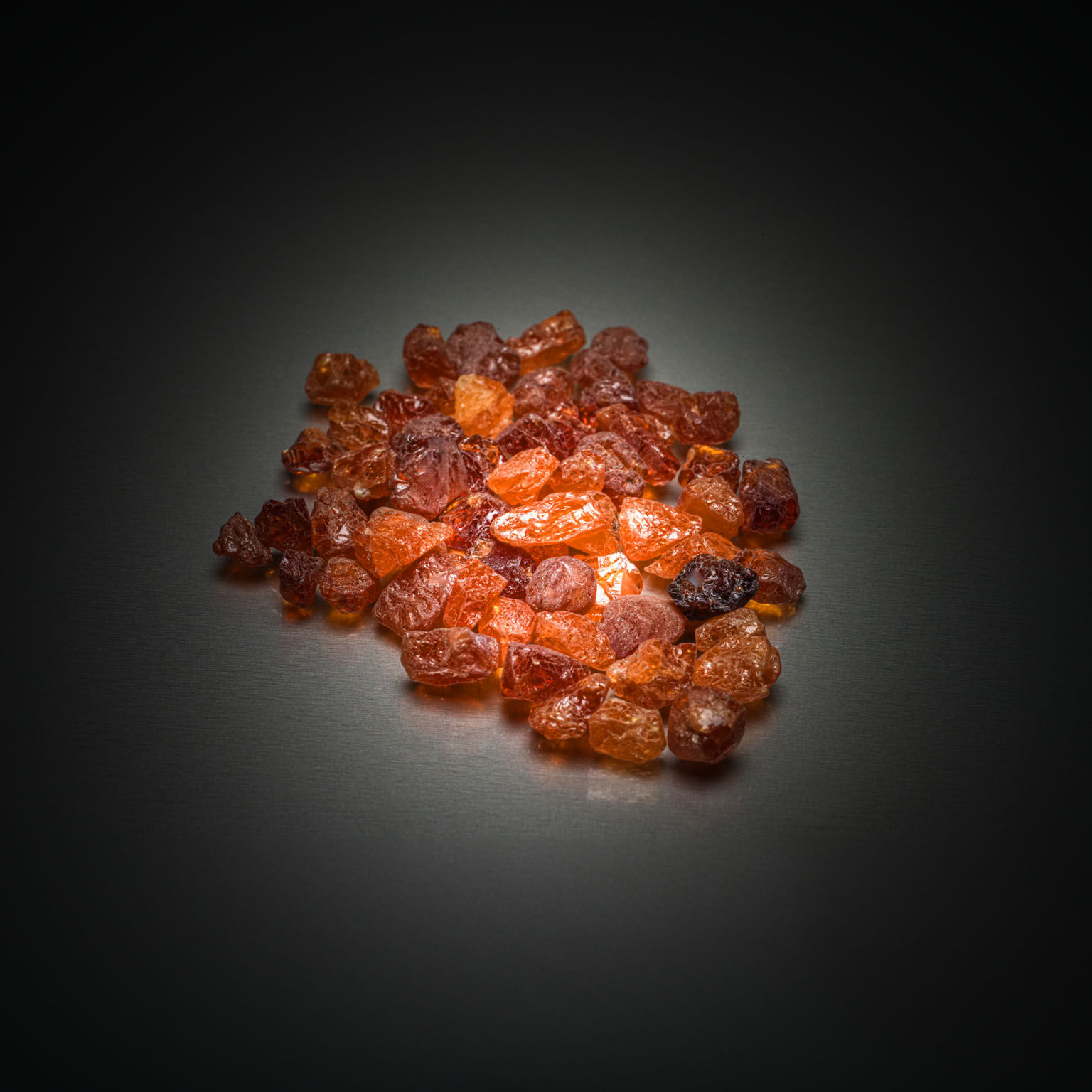 Lot de grenats spessartites oranges bruts sur papier. - Lazuli