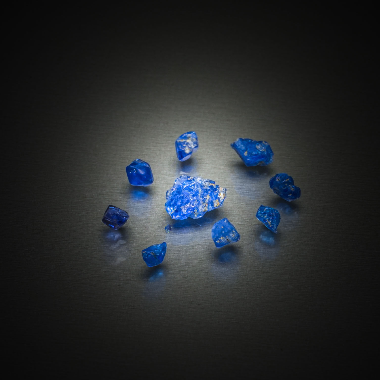 Lot de spinelles bleus cobalt bruts sur papier. - Lazuli