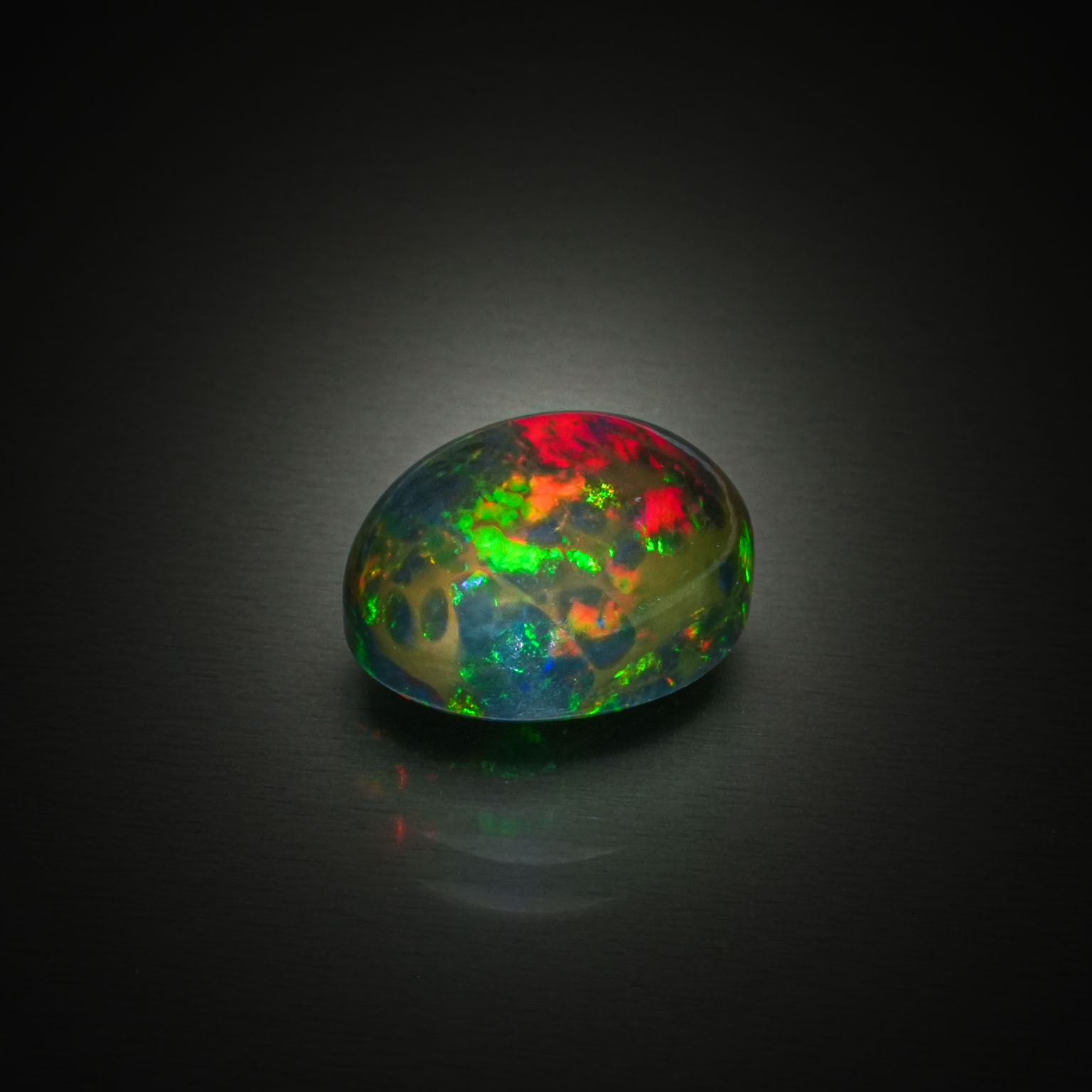 Opale noire ovale cabochon sur papier. - Lazuli