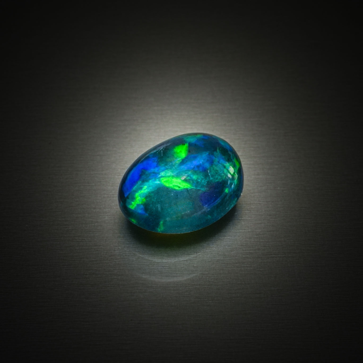 Opale noire ovale cabochon sur papier. - Lazuli