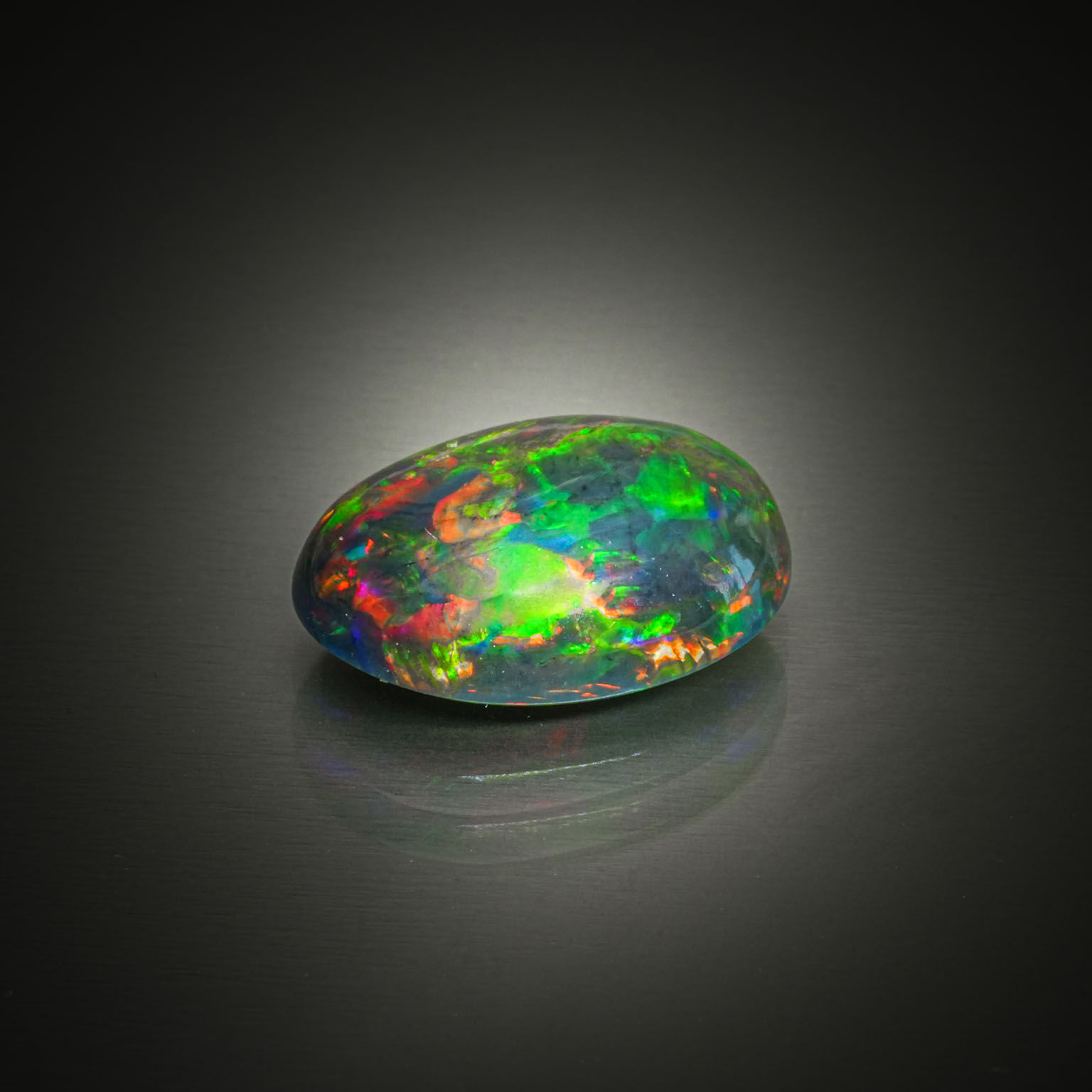 Opale noire ovale cabochon sur papier. - Lazuli