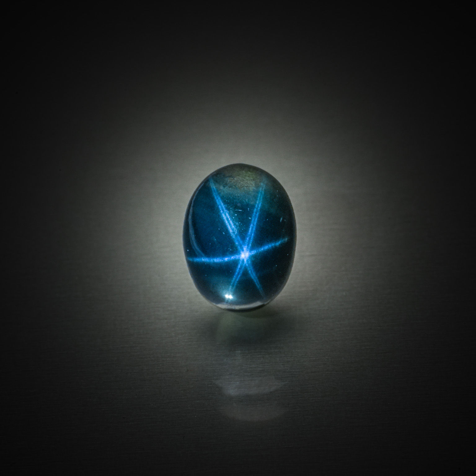 Saphir étoilé ovale cabochon sur papier. - Lazuli