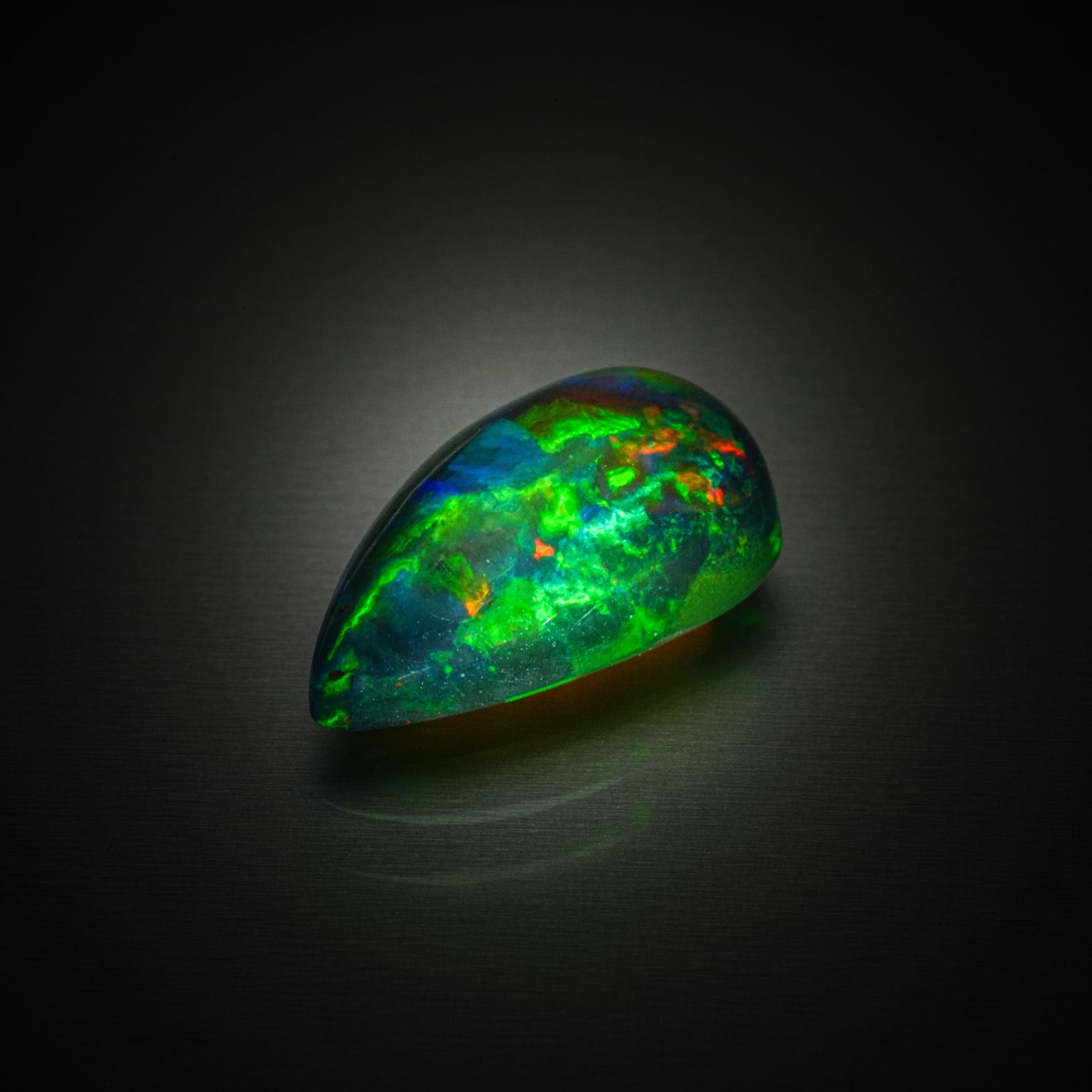Opale noire poire cabochon sur papier. - Lazuli
