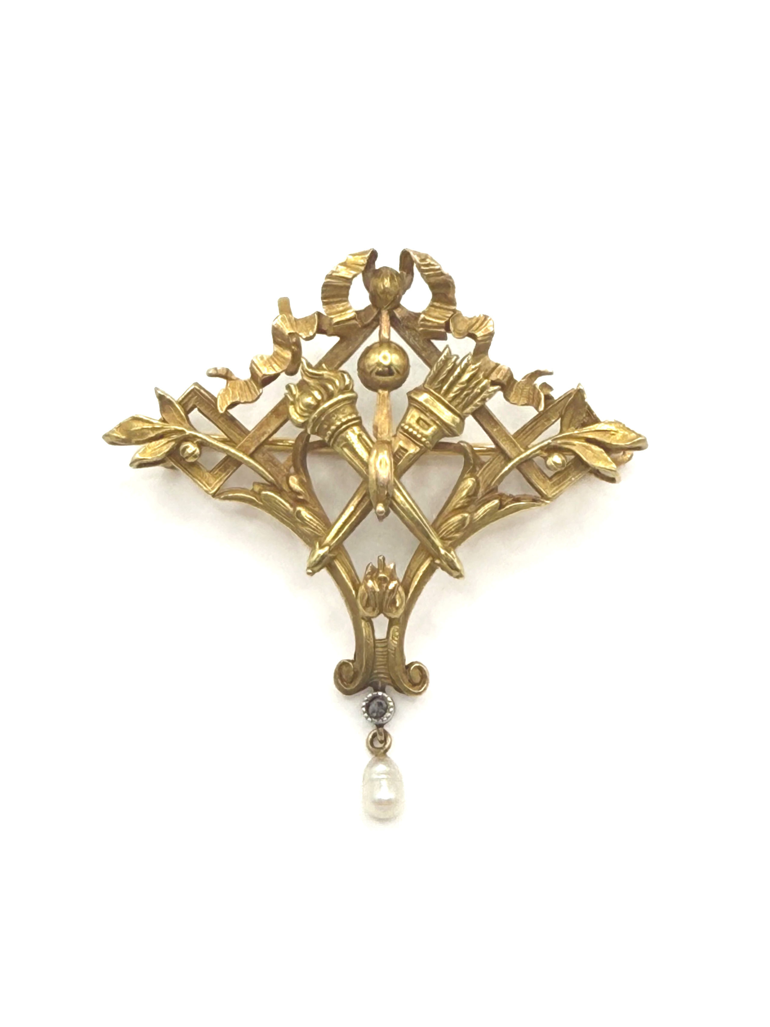 Broche ajourée en or jaune (750 millièmes) à décor de torche, carquois, nœud, feuillage et une perle en pampille. - Lazuli