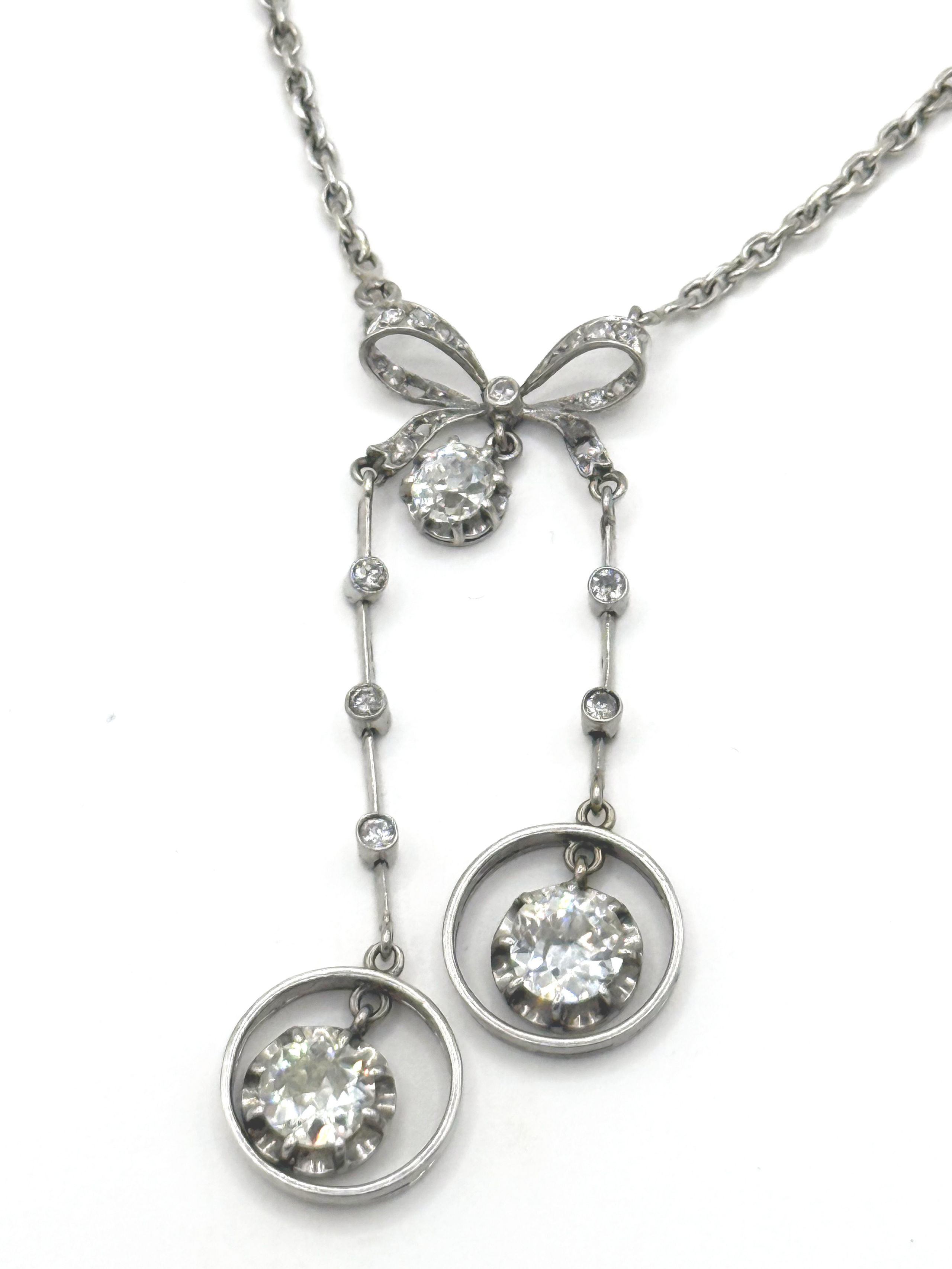 Collier négligé en or gris (750 millièmes) à maille forçat centré d’un noeud orné de diamants taille ancienne. - Lazuli