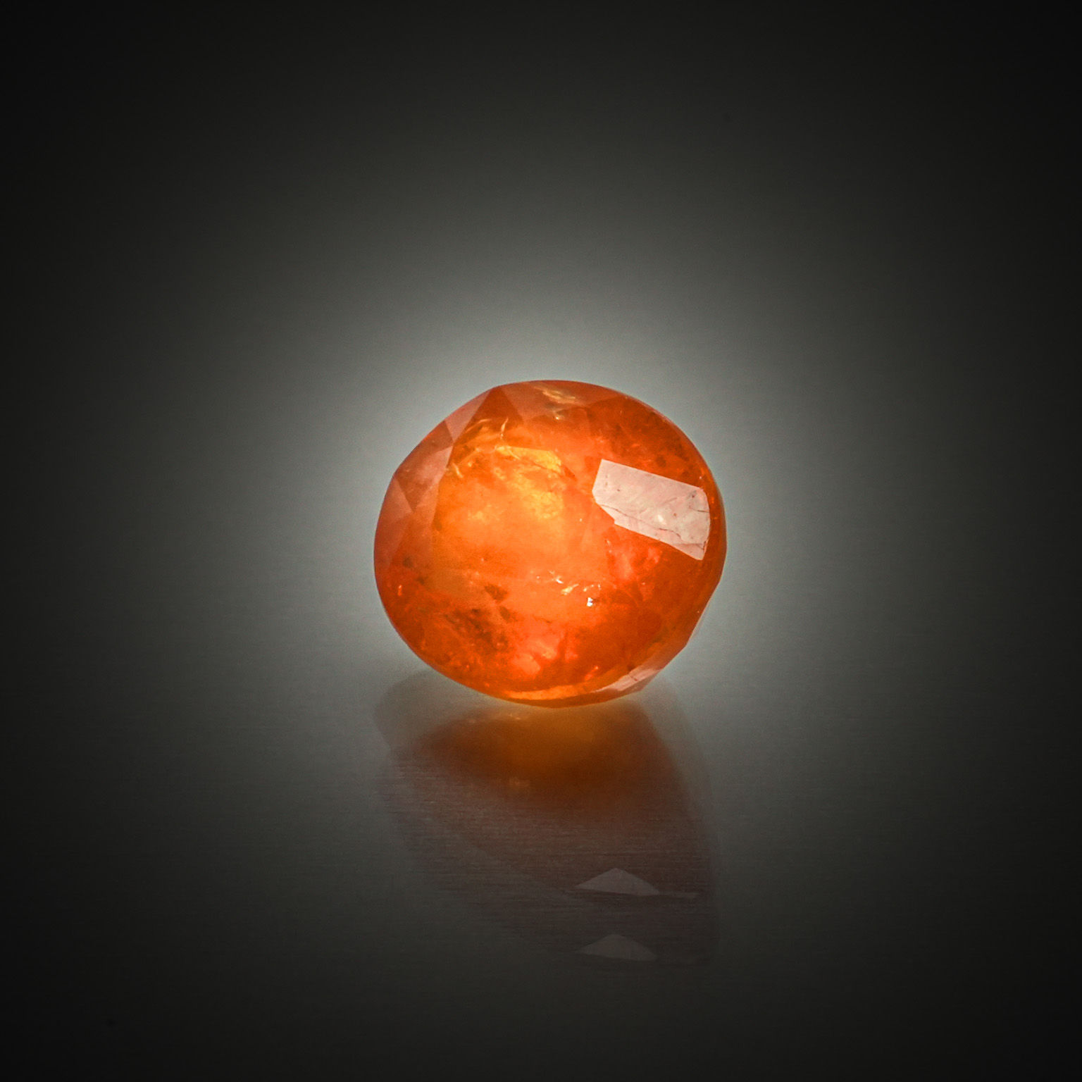 Grenat spessartite orange ovale sur papier. - Lazuli