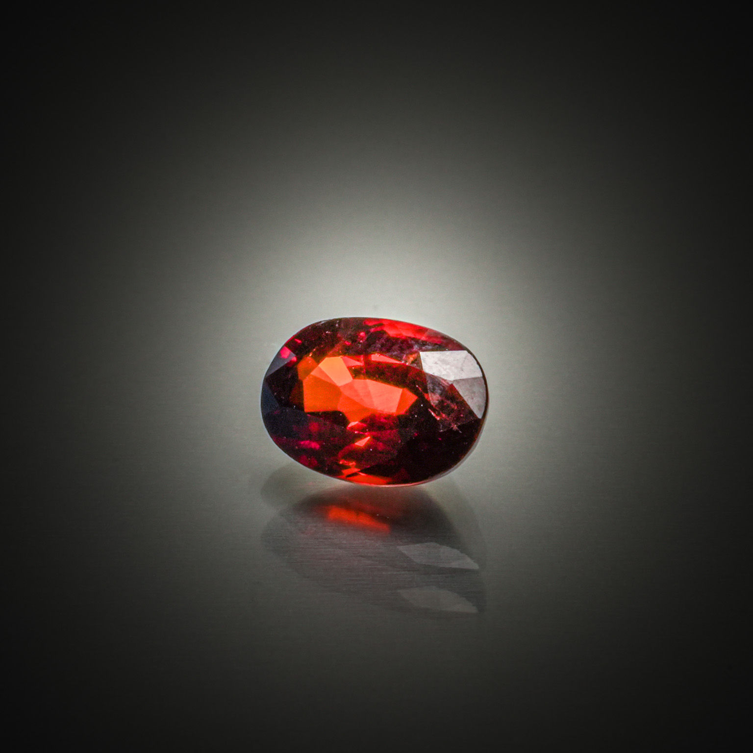 Grenat orange spessartite ovale sur papier. - Lazuli