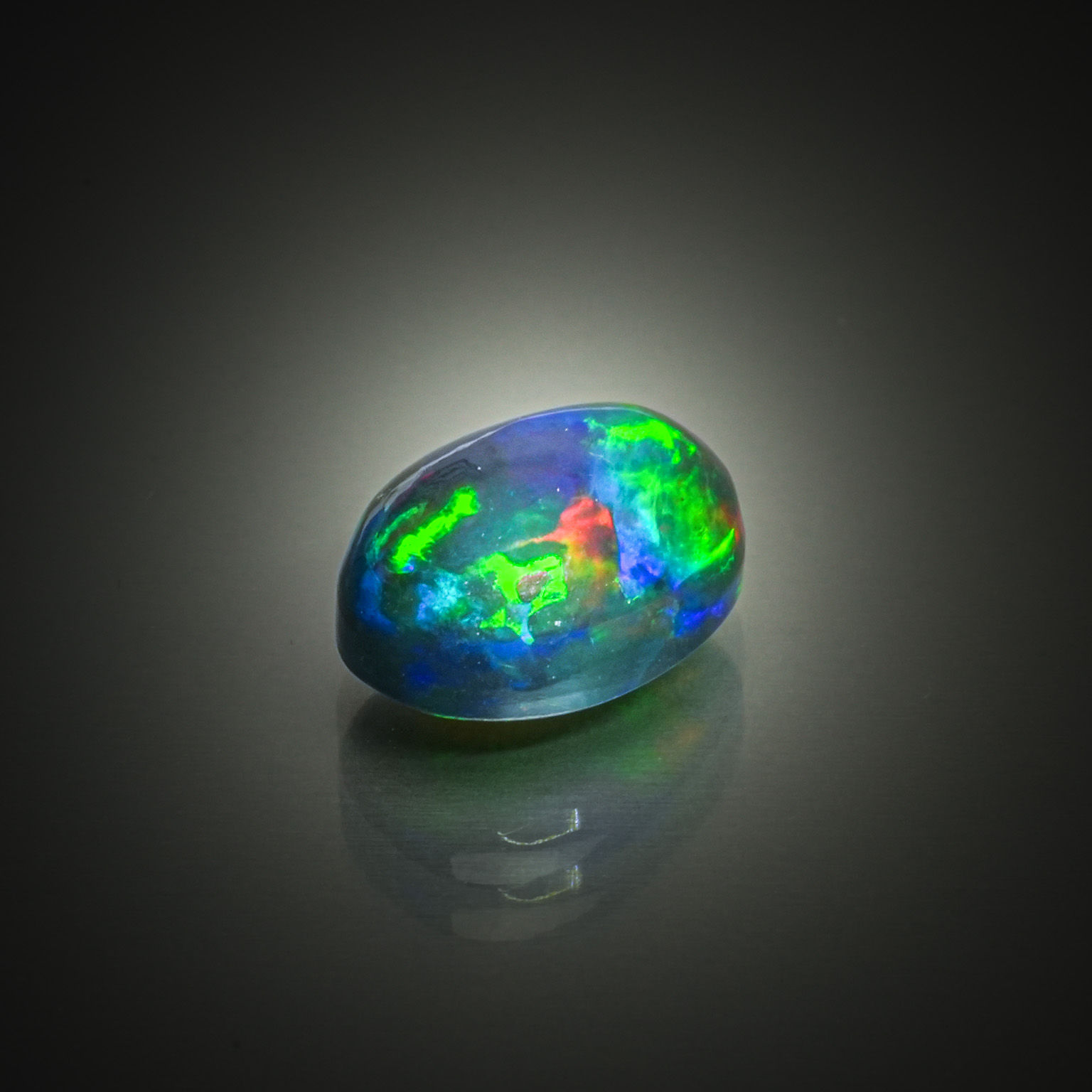 Opale noire ovale cabochon sur papier. - Lazuli