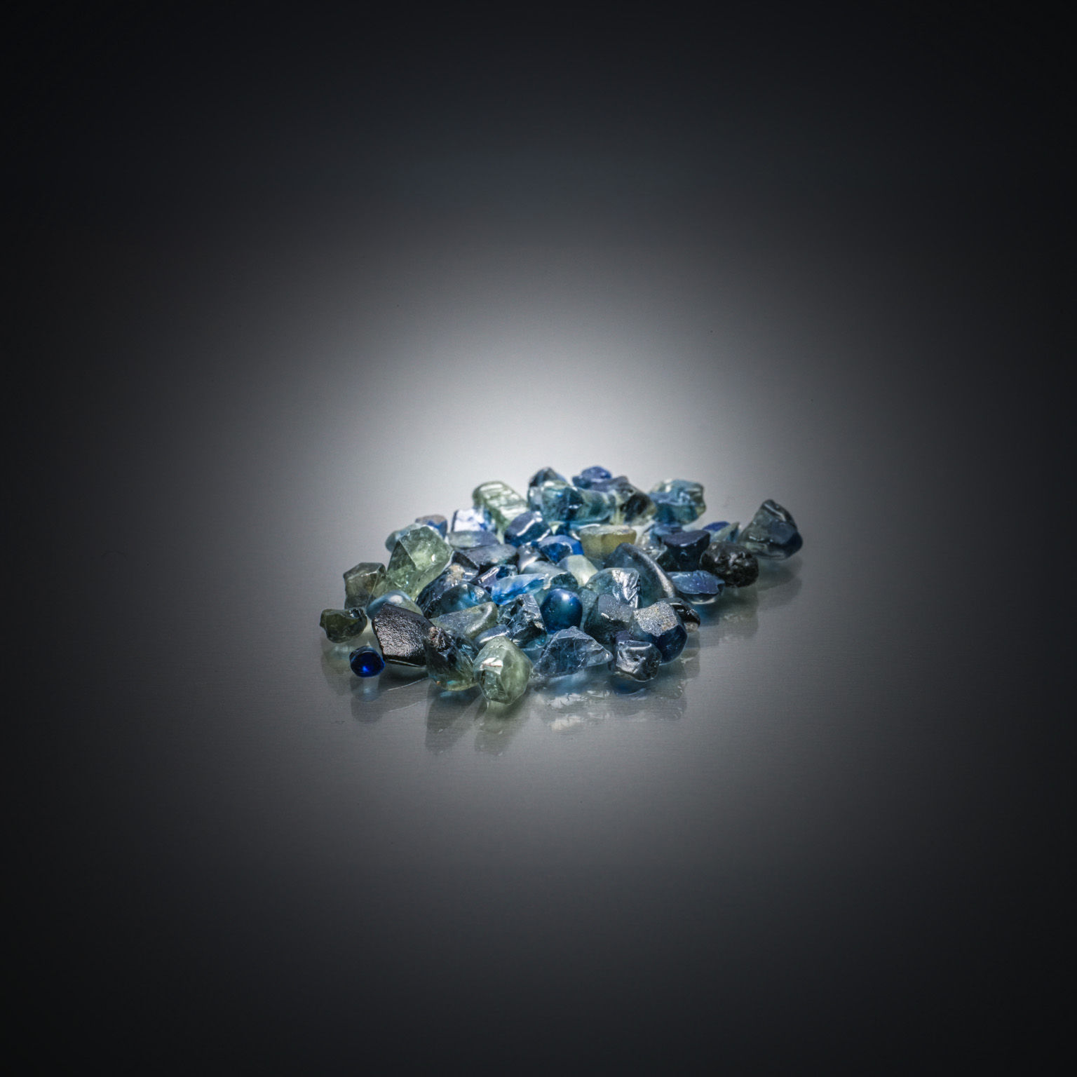 Lot de saphirs verts ronds sur papier. - Lazuli