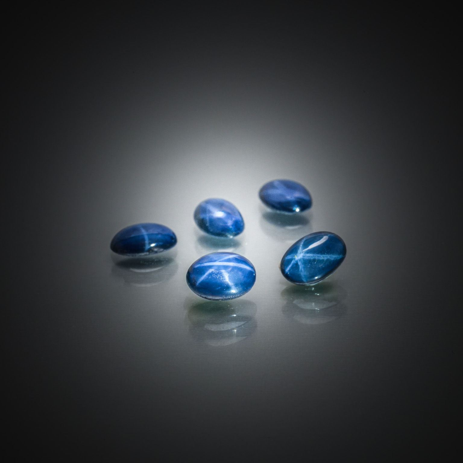 Lot de saphirs verts ronds sur papier. - Lazuli
