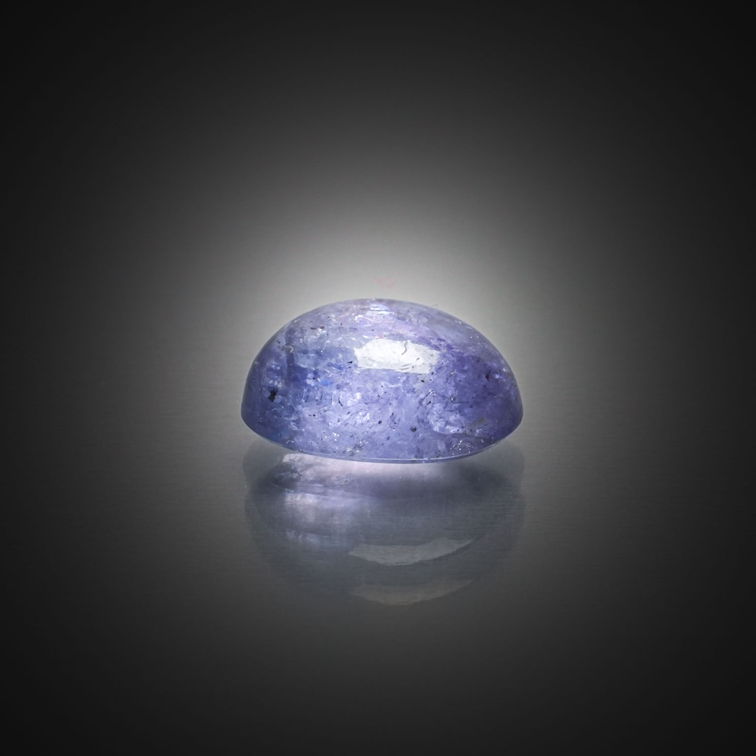 Opale noire ovale cabochon sur papier. - Lazuli