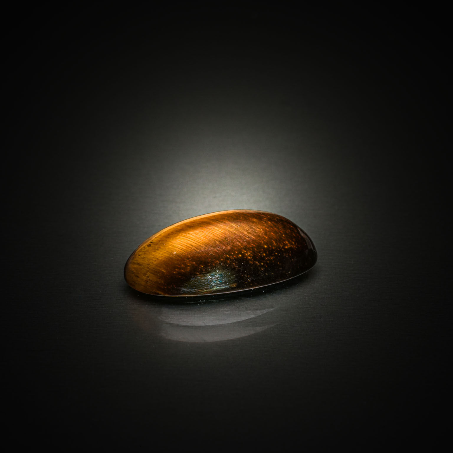 Quartz œil de tigre ovale cabochon sur papier. - Lazuli