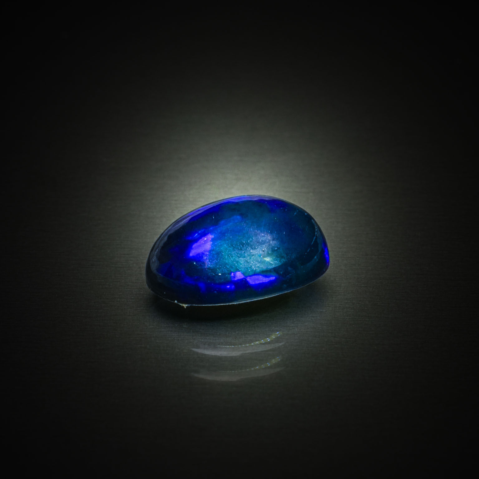 Opale noire ovale cabochon sur papier. - Lazuli
