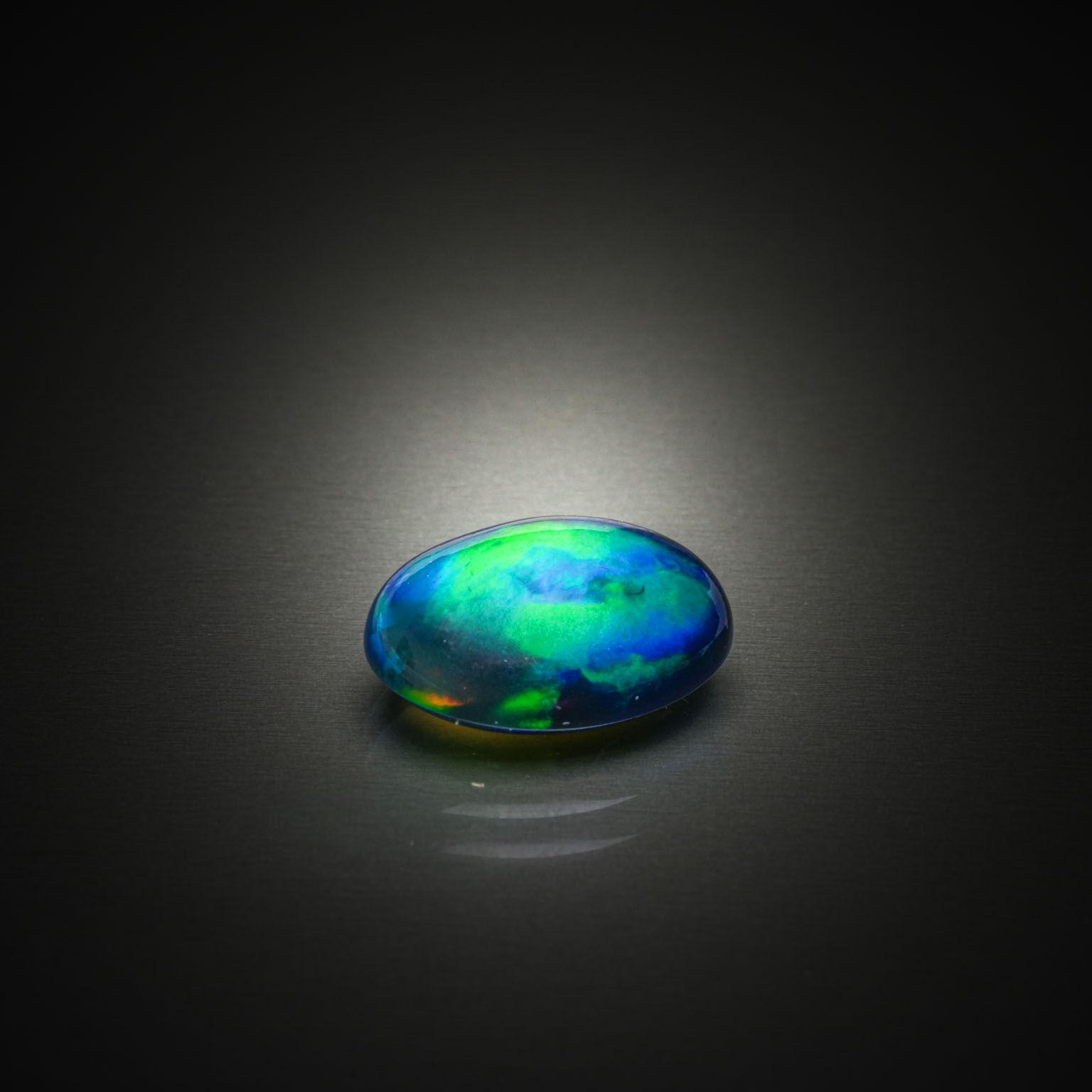 Opale noire ovale cabochon sur papier. - Lazuli