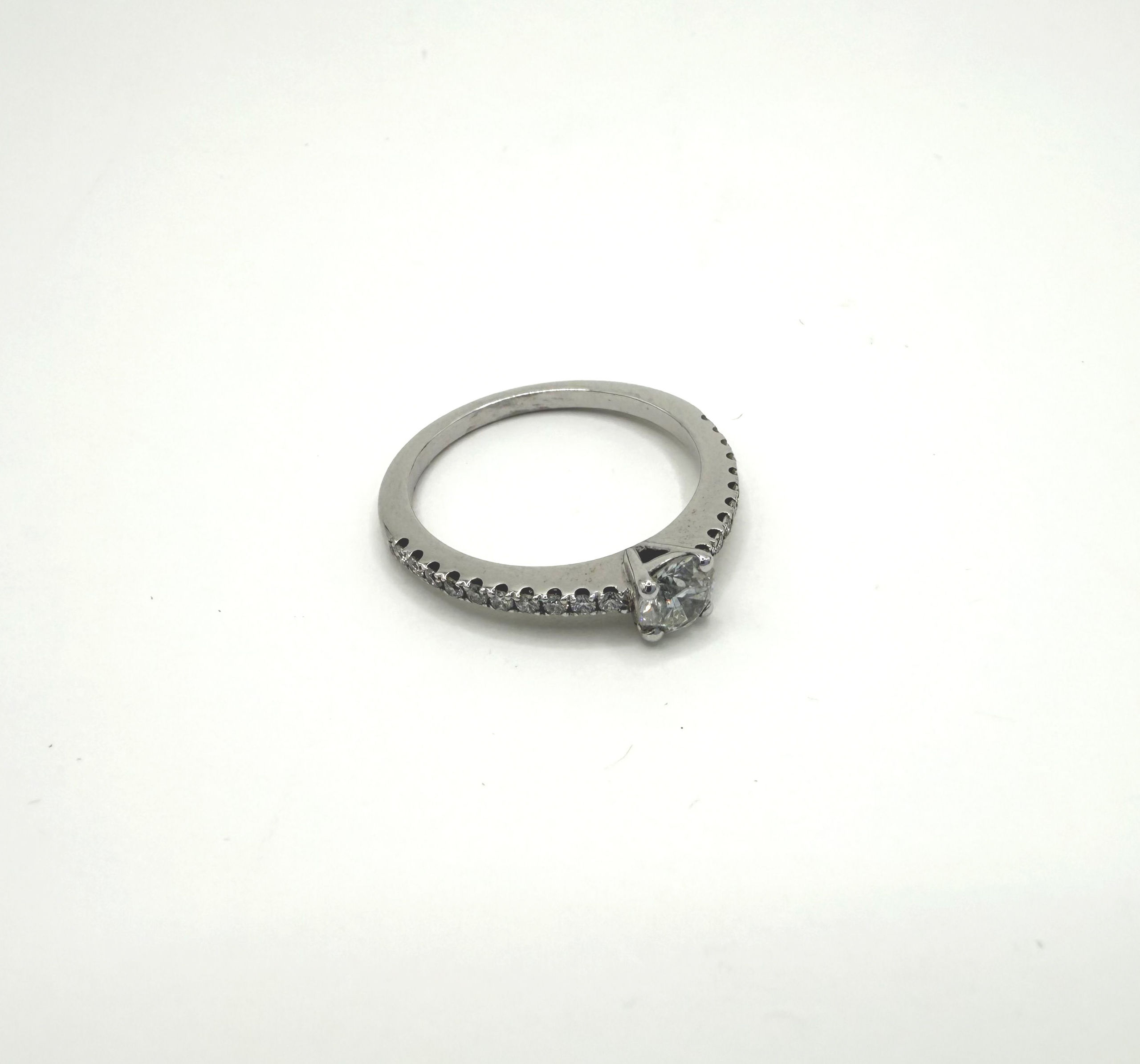 Bague ajourée en or jaune (750 millièmes) ornée d&rsquo;une émeraude rectangulaire à pans coupés dans un entourage et entrelacs de brillants. - Lazuli