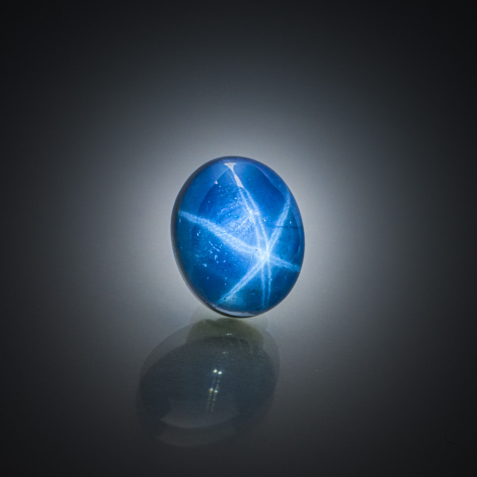 Opale noire ovale cabochon sur papier. - Lazuli